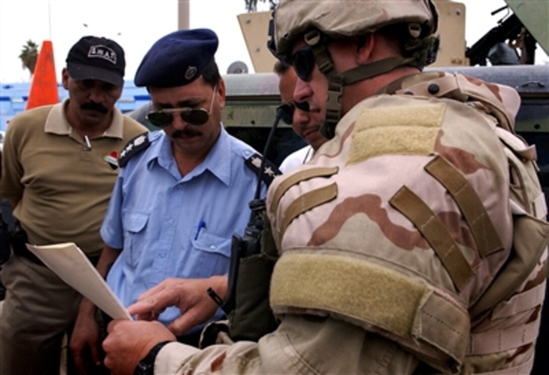 U.S. Army Staff Sgt. Bill Straily completes paperwork after delivering 100 new uniforms to the Diwaniyah Iraqi police SWAT team, Oct. 22, 2006. The U.S. Army Military Police Brigade Police Transition Team assists in the training. 