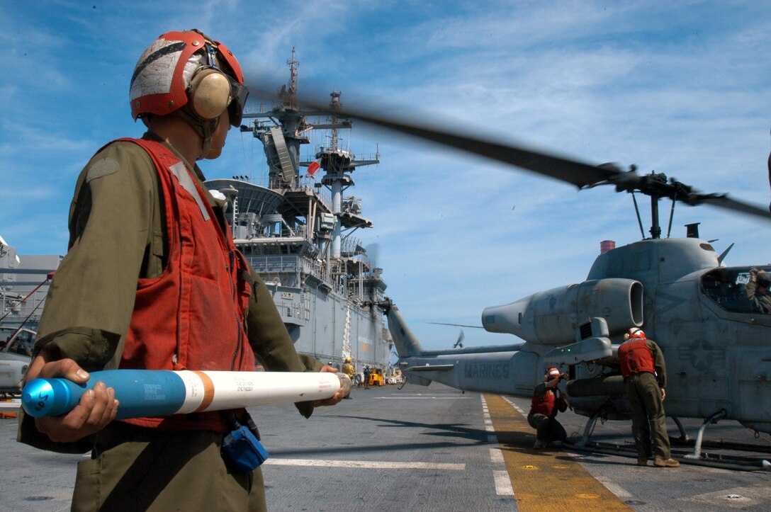 ABOARD USS BOXER, At Sea (Oct. 27, 2006) - An Aviation Ordnance Marine assigned to Marine Medium Helicopter Squadron 165 (Reinforced), 15th Marine Expeditionary Unit (Special Operations Capable) aboard USS Boxer (LHD 4) stands ready to "hot-load" a 2.75-inch rocket onto a UH-1N Huey Helicopter during Malabar 2006.  Hot-loading is loading ammunition onto an aircraft with engines running.  Malabar 2006 is the first time the Navy and Marine Corps completed a hot-load at sea.  Malabar 2006 is a multinational exercise between the U.S., Indian and Canadian armed forces to increase interoperability between the three nations and support international security cooperation missions.  U.S. Navy photo by Mass Communications Specialist Seaman James Seward.  (RELEASED)