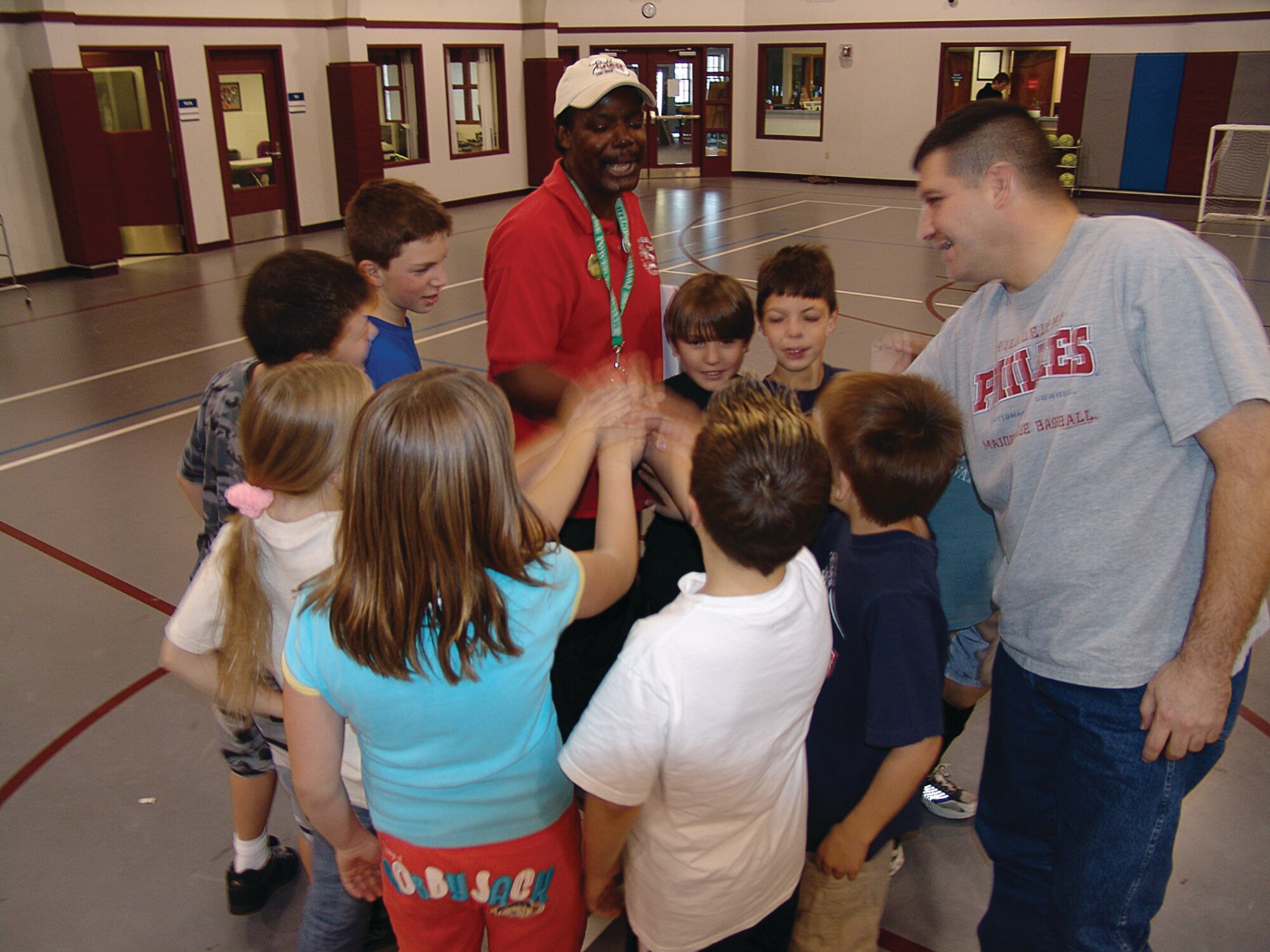 Chuck Finney, center and coach Master Sgt. Tim Anton, 367th Recruiting Squadron, lead the team members of the Knights and Spider Monkeys in a Spider Knights cheer following soccer practice in the youth center here Saturday.  Teams are practicing for this year's season.  The first game is scheduled for Nov. 6, 2006 in the youth center.