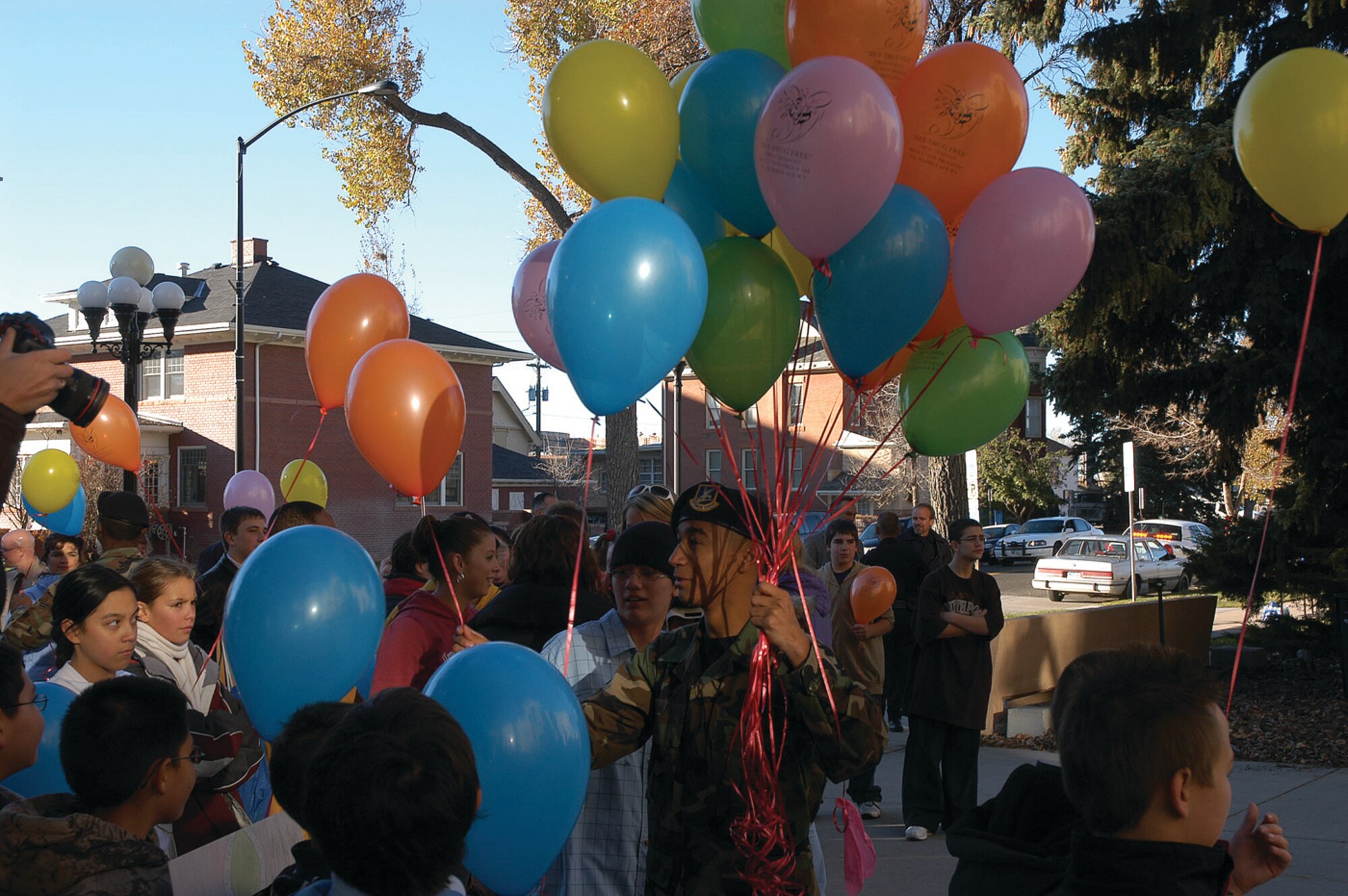 Airman 1st Class Raul Salas Jr., 90th Security Forces Squadron, hands out balloons at the Red Ribbon Week kick-off event in front of the Wyoming Capitol Building.  Red Ribbon Week is an annual campaign whose mission is to present a united and visible commitment of a drug-free America