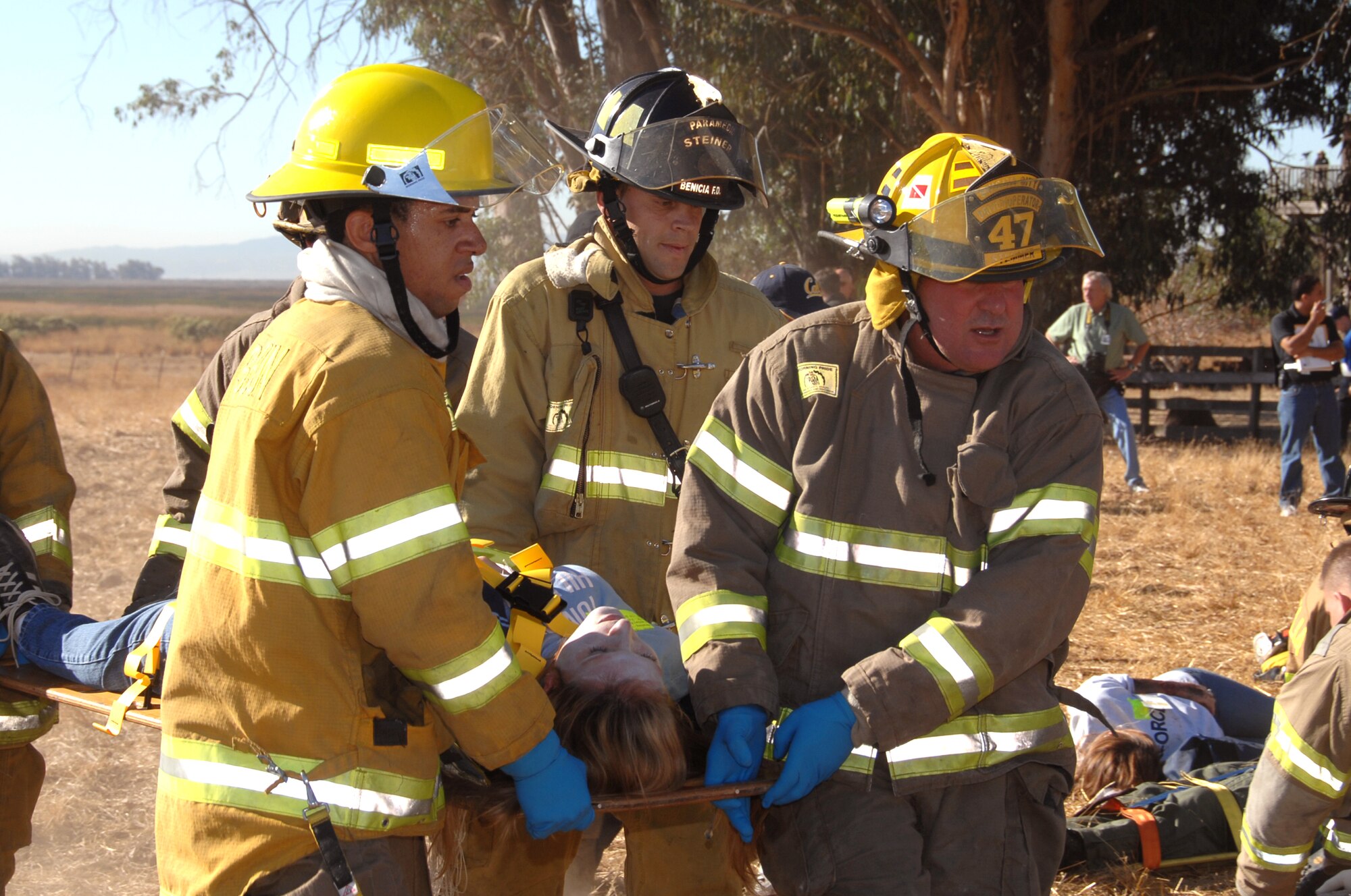 Mr. Amir Ervin, [left] Suisun City volunteer firefighter recruit, Mr. Ken Steiner, Benicia paramedic firefighter and Mr. Ed Stemmer, Suisun volunteer fire fighter, carry a “injured’”person out of the simulated crash site for further medical attention. Travis, along with 32 off-base agencies, held a joint exercise Oct. 19 to test readiness capability to respond to off-base disasters.  (U.S. Air Force photo by Nan Wylie)