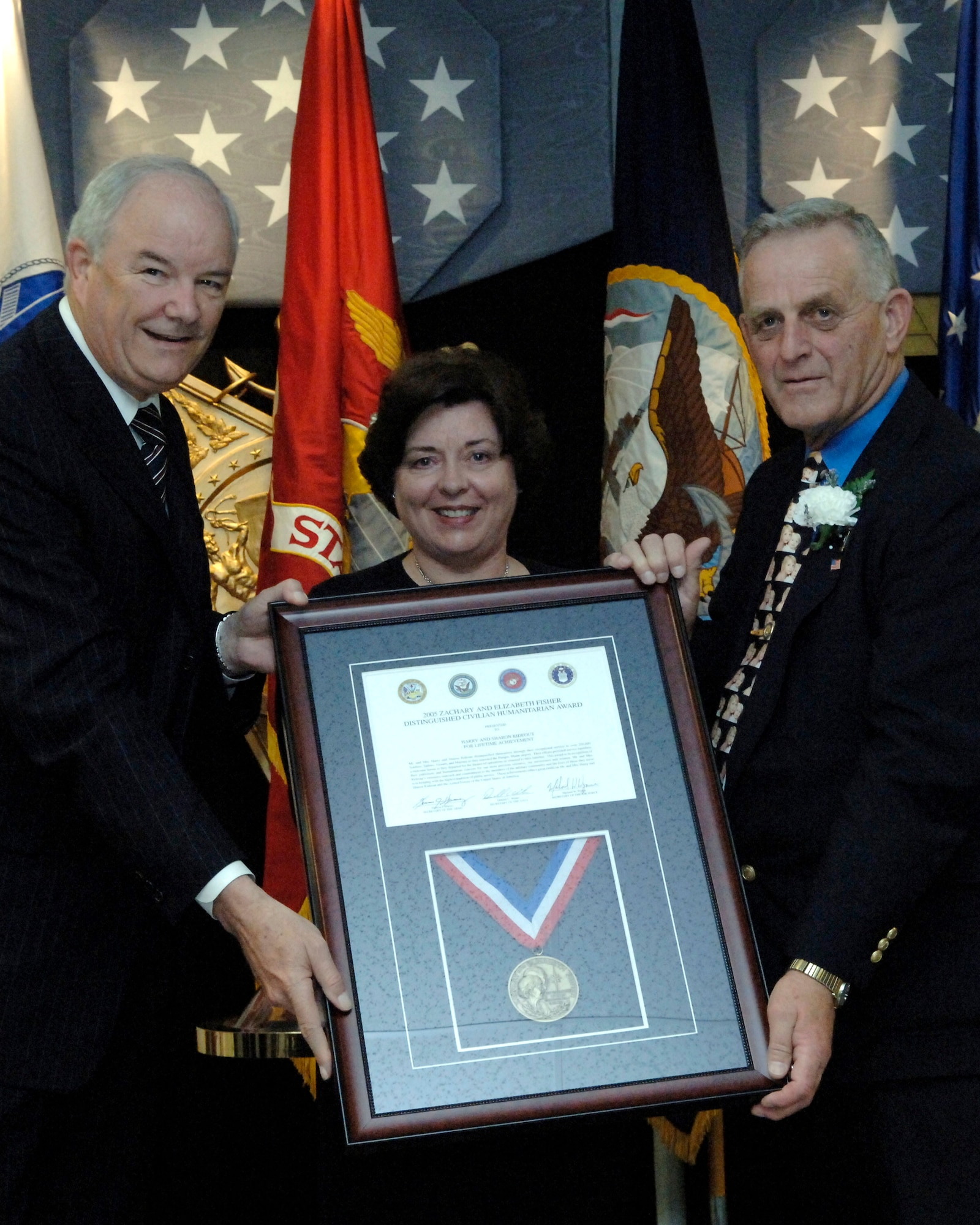 Secretary of the Air Force Michael W. Wynne presents Sharon and Harry Rideout with the 2006 Zachary and Elizabeth Fisher Distinguished Civilian Humanitarian Award Oct. 26 at the Pentagon.  Among their many accomplishments to support servicemembers, the Rideouts created the Bangor Greeters Group at Bangor International Airport, Maine.  The all-volunteer group greets Soldiers, Sailors, Airmen and Marines as they pass through the airport, either going to or returning from overseas deployments. (U.S. Air Force photo/Ron C. Hall)
