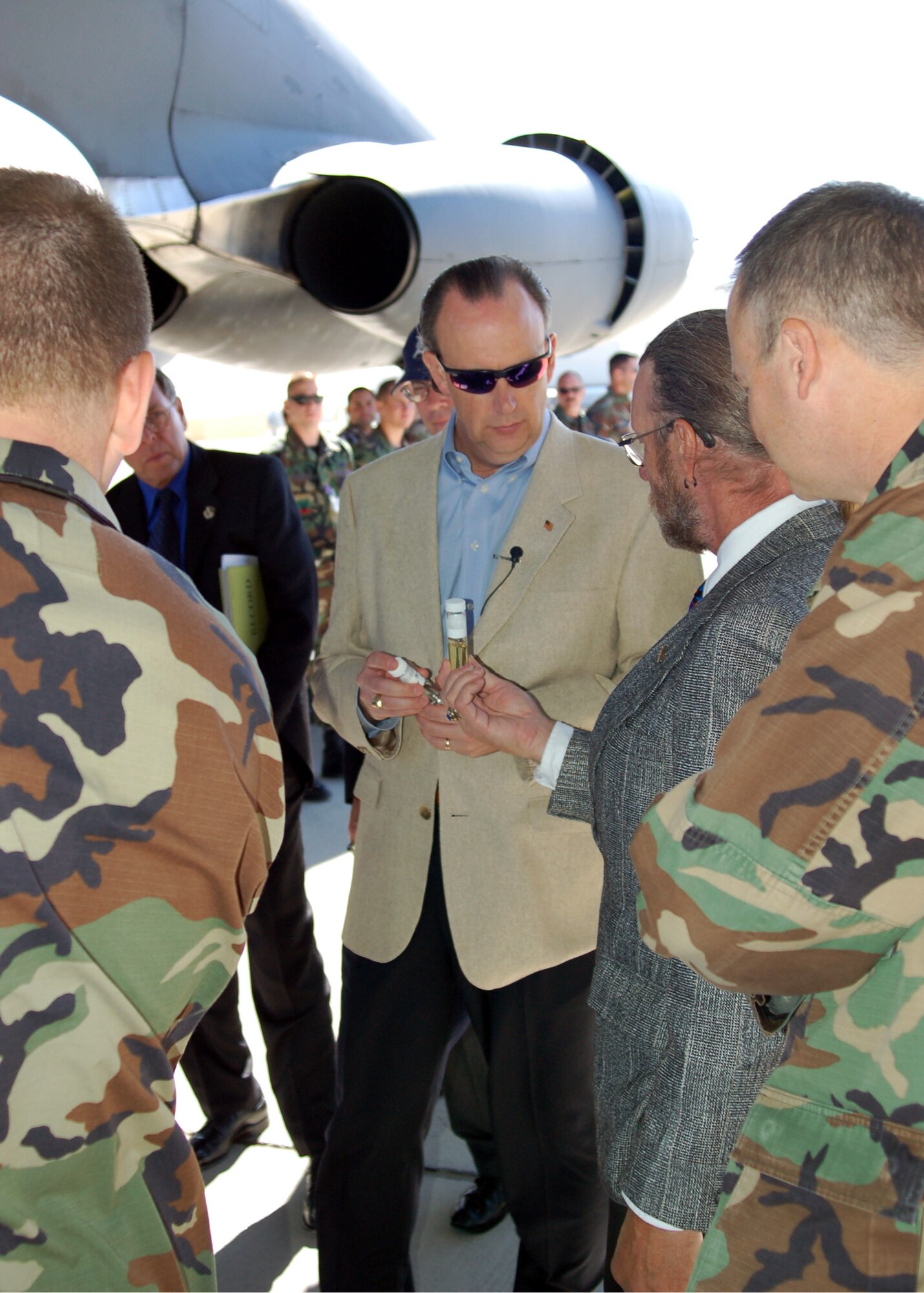 William C. Anderson reviews samples of the Fischer-Tropsch fuel under the wing of the B-52 used during a recently alternative fuels test at Edwards Air Force Base, Calif., Oct. 25. The alternative fuel used was a 50-50 blend of traditional crude-oil based jet fuel and the Fischer-Tropsch fuel derived from natural gas. Mr. Anderson is the assistant secretary of the Air Force for installations, environment and logistics. (Courtesy photo)