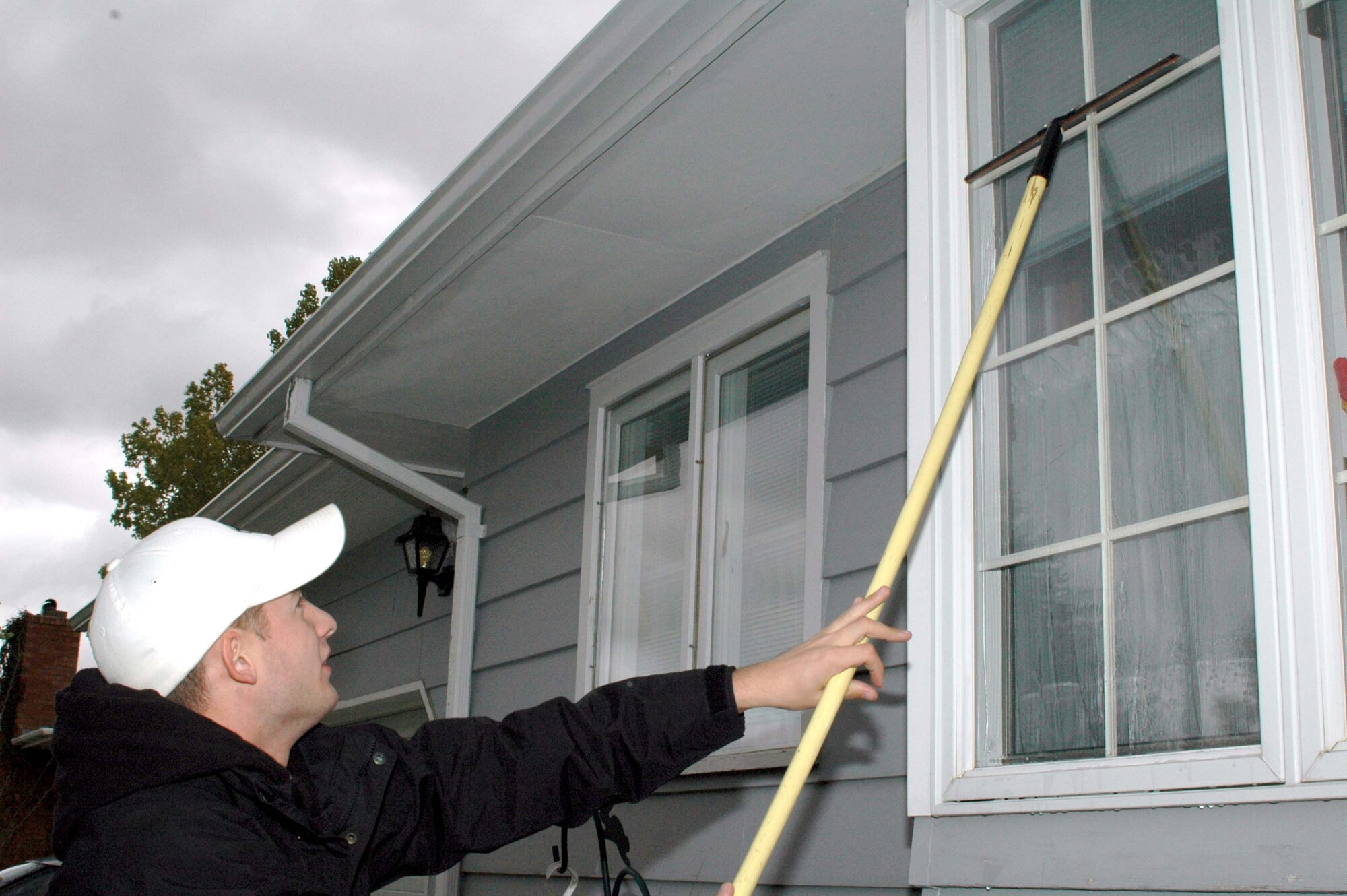 Airman 1st Class Caleb Jones, 341st Missile Maintenance Squadron, washes a homeowner's windows during the Day of Caring Oct. 20