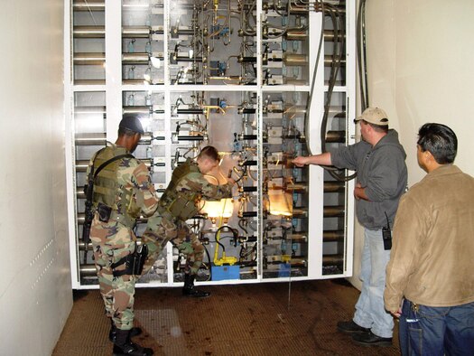 Airman 1st Class Derrick Warfield manually locks a 25-ton blast door at Cheyenne Mountain Air Force Station, Colo., during a recent operational readiness inspection. Looking on are Senior Airman Anthony Williams and two contractors from the 721st Mission Support Group civil engineer division. The two Airmen are with the 721st Security Forces Squadron.  (U.S. Air Force photo/1st Lt. Jeff Crepeau) 