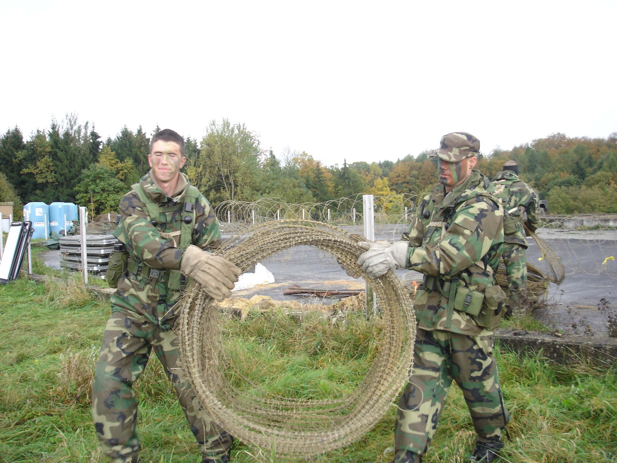 Airman Stephen Howard (left) and Senior Airman Eric Villafana secure their camp with constantine wire during the combat readiness course on Bitburg Air Base, Germany, Oct. 23. Both AIrmen are from the 1st Combat Communications Squadron. (U.S. Air Force photo/Capt. Erin Dorrance)