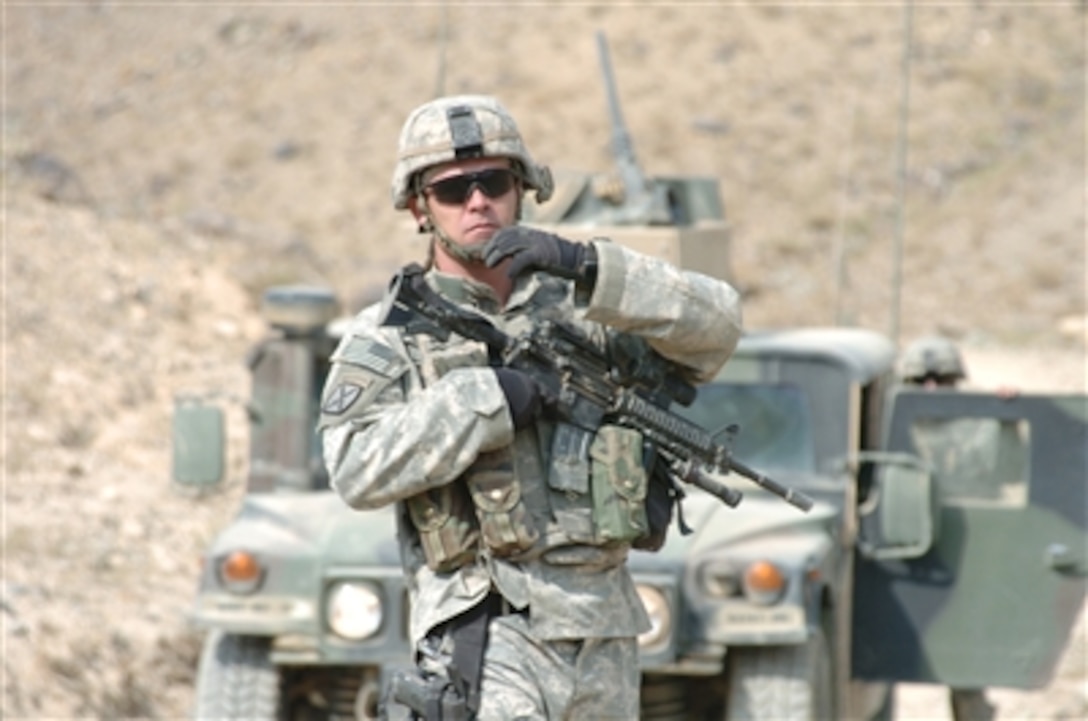 U.S. Army Staff Sgt. Norman Bone directs movement as his patrol turns around on a narrow path in the mountains of Parwan province in Afghanistan on Oct. 25, 2006.  Bone is a patrol leader for the 561st Military Police Company, Fort Campbell, Ky., attached to 10th Mountain Division.  