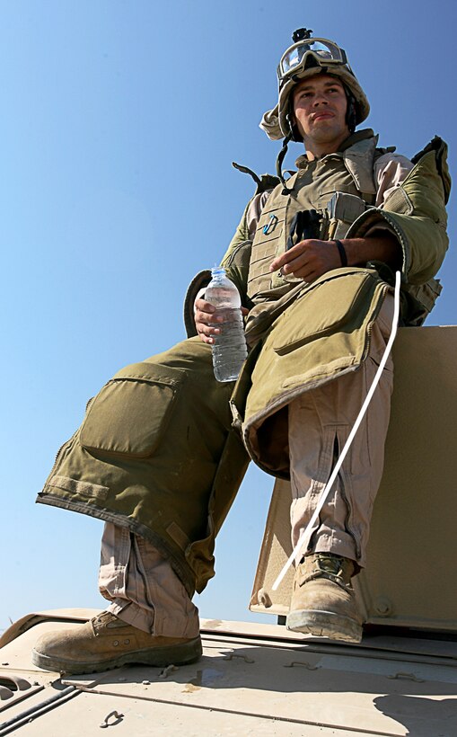 Lance Cpl. Tiago Soltes, a gunner for the explosive ordinance disposal squad of Security Company, Combat Logistics Battalion 5, 1st Marine Logistics Group (Forward) relaxes and re-hydrates just moments before leaving base for another mission.  When the EOD security squad gets a call, they respond in minutes.  ?You get a kind of adrenalin rush,? said Soltes, 23 from Roselle, Ill., ?you just have to keep your head in the game; you have to keep focused on everything and just go with the flow.?  Two EODs squads rotate on twenty-four hour shifts.  During the shift, they train, eat, and rest all within the compound.  When they receive the order, often everything else stops; all that matters is the mission ahead.  They can react to a call at any time.