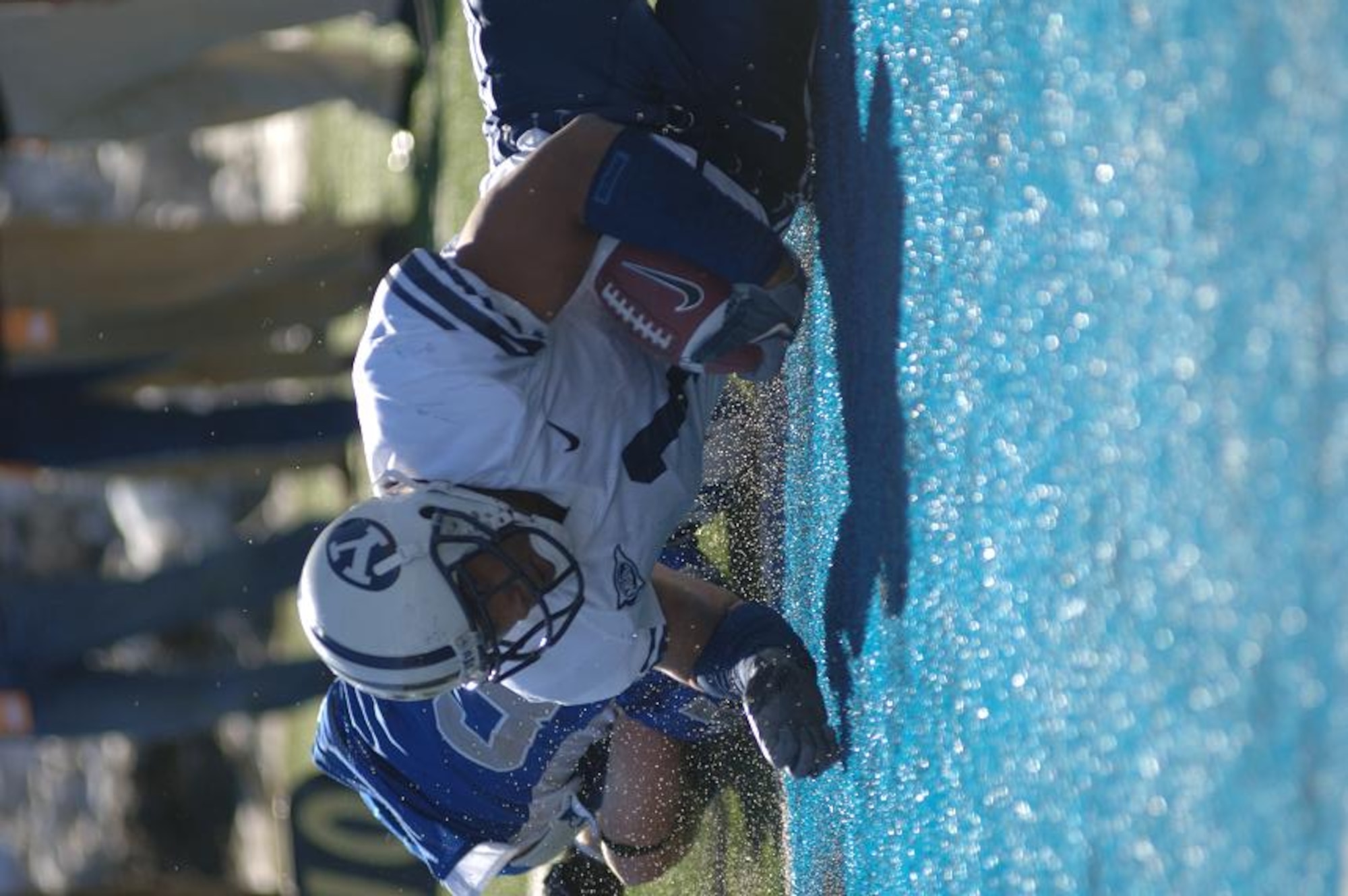 BYU running back Fui Vakapuna lands in the end zone after hurtling over Falcon linebacker Drew Fowler on a John Beck pass. The score put BYU ahead in the fourth quarter, 30-7. Vakapuna accounted for two touchdowns and 70 of BYU's 411 total offensive yards. BYU won, 33-14.  (U.S. Air Force Photo/1st Lt. John Ross)
