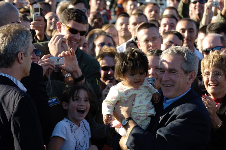 President George W. Bush holds a baby while greeting people after giving a motivational speech to the troops at Charleston Air Force Base, S.C., on Oct. 28, 2006. President Bush came to South Carolina to thank the Airmen at Charleston AFB for their contributions to the Global War on Terrorism. (U.S. Air Force photo by Senior Airman Desiree N. Palacios)(Released)