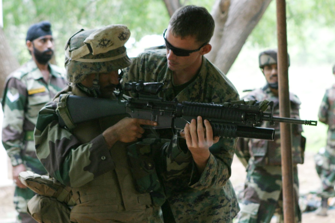BELGAUM, India (Oct. 29, 2006) - Cpl. Matthew Scott, an infantry man with 1st Platoon, Echo Co., Battalion Landing Team 2/4, shows an Indian soldier with Alpha Co., 21st Battalion, The Punjab Regiment, how to properly hold an M16A4 service rifle during immediate action drills at the Lico Training Area here. Marines of Echo Co. are participating in Exercise Shatrujeet 06, which began 25 October 2006 where they are currently training with the Indian Army in basic infantry tactics. The 15th Marine Expeditionary Unit (Special Operations Capable), part of the Boxer Expeditionary Strike Group aboard the USS Boxer (LHD 4), USS Dubuque (LPD 8) and the USS Comstock (LSD 45), is currently deployed in the Western Pacific region.