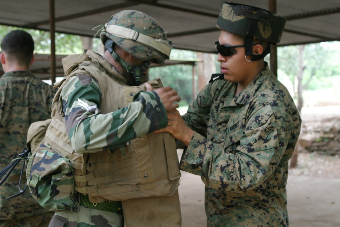 BELGAUM, India (Oct. 29, 2006)--Lance Cpl. Emilian Sanchez, an infantry man with 1st Platoon, Echo Co., Battalion Landing Team 2/4, switches out his military gear with a soldier with the Indian army?s Alpha Co., 21st Battalion, The Punjab Regiment, at the Lico Training Area here. Marines of Echo Co. are participating in Exercise Shatrujeet 06, which began 25 October 2006 where they are currently training with the Indian Army in basic infantry tactics. The 15th Marine Expeditionary Unit (Special Operations Capable), part of the Boxer Expeditionary Strike Group aboard the USS Boxer (LHD 4), USS Dubuque (LPD 8) and the USS Comstock (LSD 45), is currently deployed in the Western Pacific region.