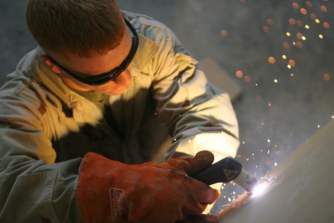 Lance Cpl. Travis D. Bryant, 23, a motor vehicle mechanic with Maintenance Company, Combat Logistics Battalion 1, 1st Marine Logistics Group (Forward), and an Elizabethtown, Ky., native, welds placement holes for upgraded armor doors as part of a humvee modification project in Al Asad, Iraq. The Marine Corps has increased the strength of the protective plating on vehicles since the start of Operation Iraqi Freedom. The upgraded doors help protect servicemembers against fragmentation from the blast of an improvised explosive device. Some humvees are arriving in Iraq with the armor kits already installed; the Marines at CLB-1 ensure the rest are upgraded to the same level of protection. The team is also making modifications to the vehicles already on hand, some of which have been previously damaged.