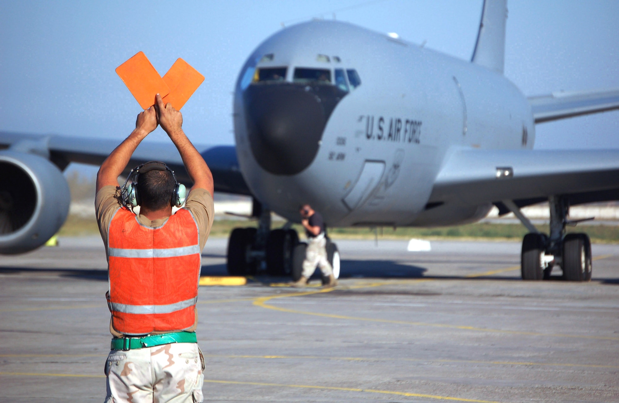 Senior Airman Joe Boullt signals a KC-135 Stratotanker crew to hold in place prior to marshalling the aircraft for takeoff. Airman Boullt is a KC-135 crew chief deployed from the 92nd Aircraft Maintenance Squadron, Fairchild Air Force Base, Wash. (U.S. Air Force photo/Master Sgt. Mitch Gettle)