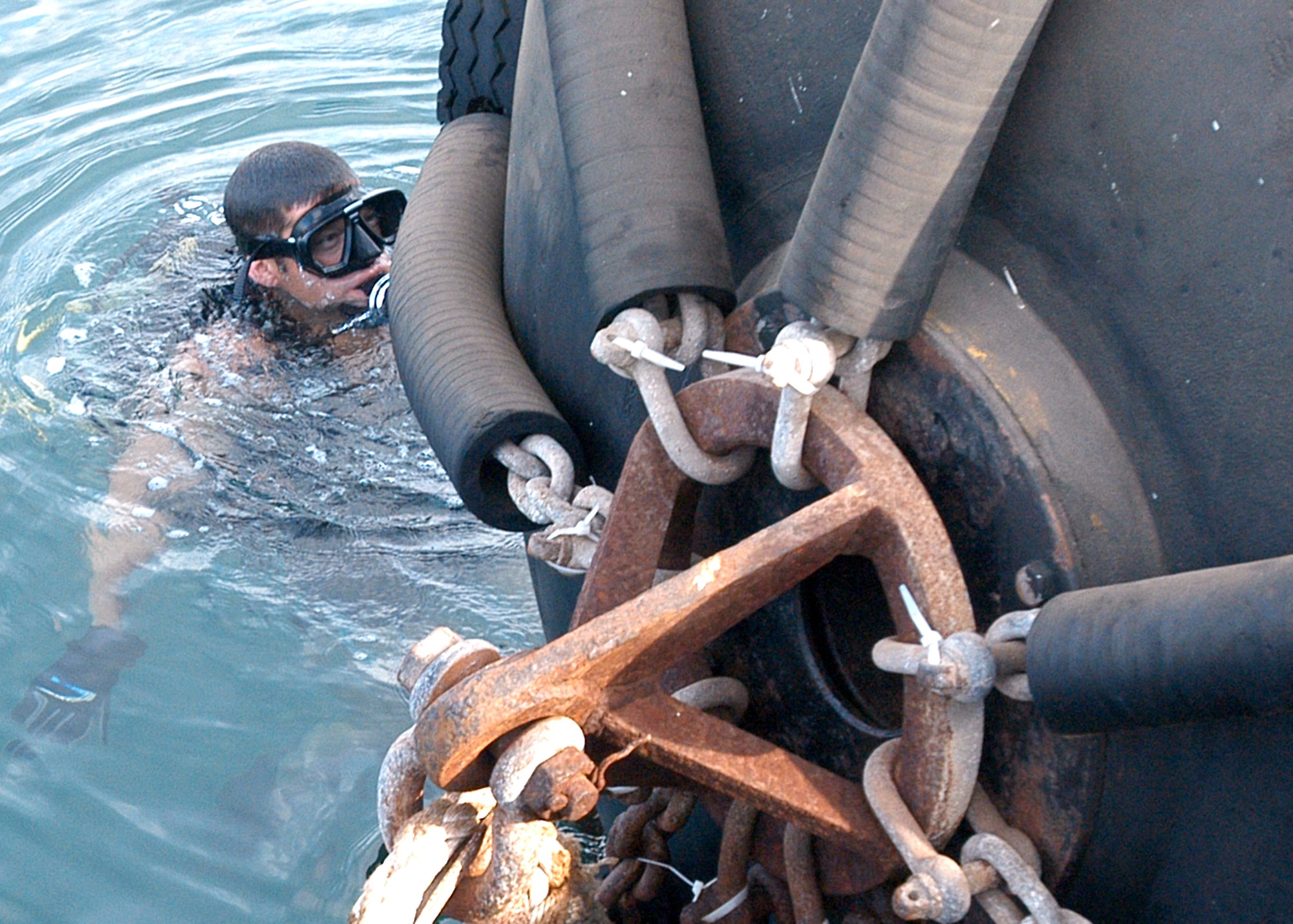 Sean Robertson, a U.S. Navy explosive ordnance disposal chief, sweeps a buoy for explosive devices Oct. 15 as part of a joint procedure to secure a pier for an incoming naval ship at the port in Djibouti City, Djibouti. (Air Force photo/Senior Airman Sarah E. Stegman)