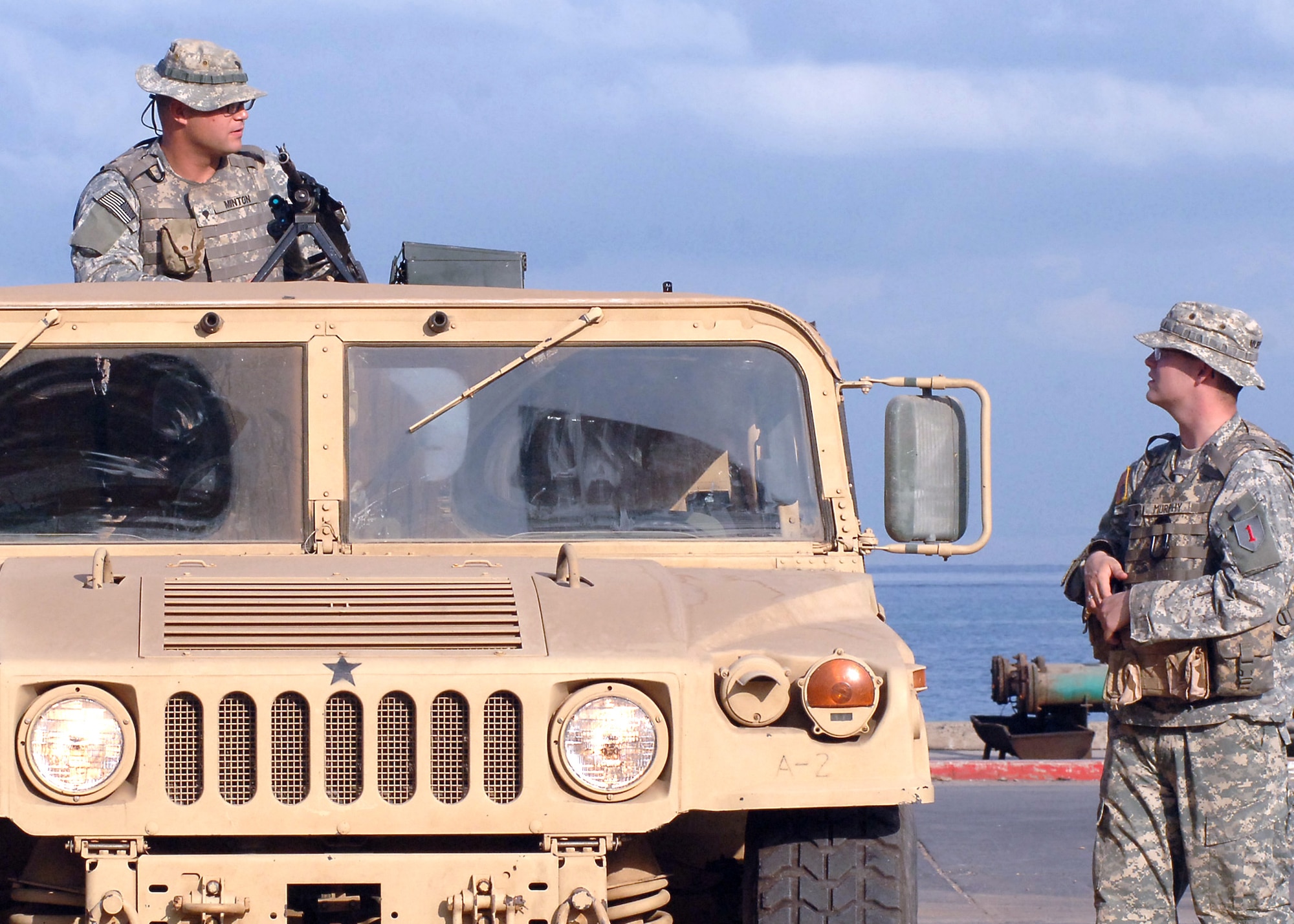 Army Specs. Nicholas Minton (left) and James Murphy provide security at the port in Djibouti City, Djibouti, Oct. 15 as part of a joint procedure to secure a pier for an incoming naval ship.  The soldiers are assigned to the 1st Battalion, 16th Infantry, Alpha Co.  (U.S. Air Force photo/Senior Airman Sarah E. Stegman)