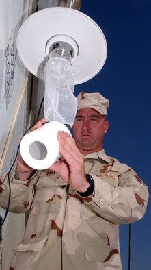 Staff Sgt. Robbie Crumpton, 380th Expeditionary Civil Engineer Squadron, examines a "light trap" for bugs.  The light trap allows Sergeant Crumpton, who works in the entomology flight, and the public health flight to see what sorts of bugs are in season and the potential for diseases like malaria and more.  (U.S. Air Force photo/Master Sgt. Jason Tudor)