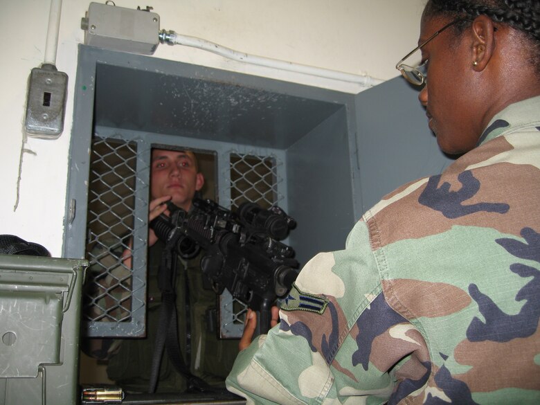 Airman 1st Class John Wilkerson, 39th Security Forces Squadron member, hands his weapon to Airman 1st Class Nichelle Ingram, 39th SFS armer, during shift change Oct. 30. The armory made changes to quickly get security forces members in and out of the armory in timely matter saving valuable time for other things. (U.S. Air Force photo by Senior Airman Patrice Clarke)