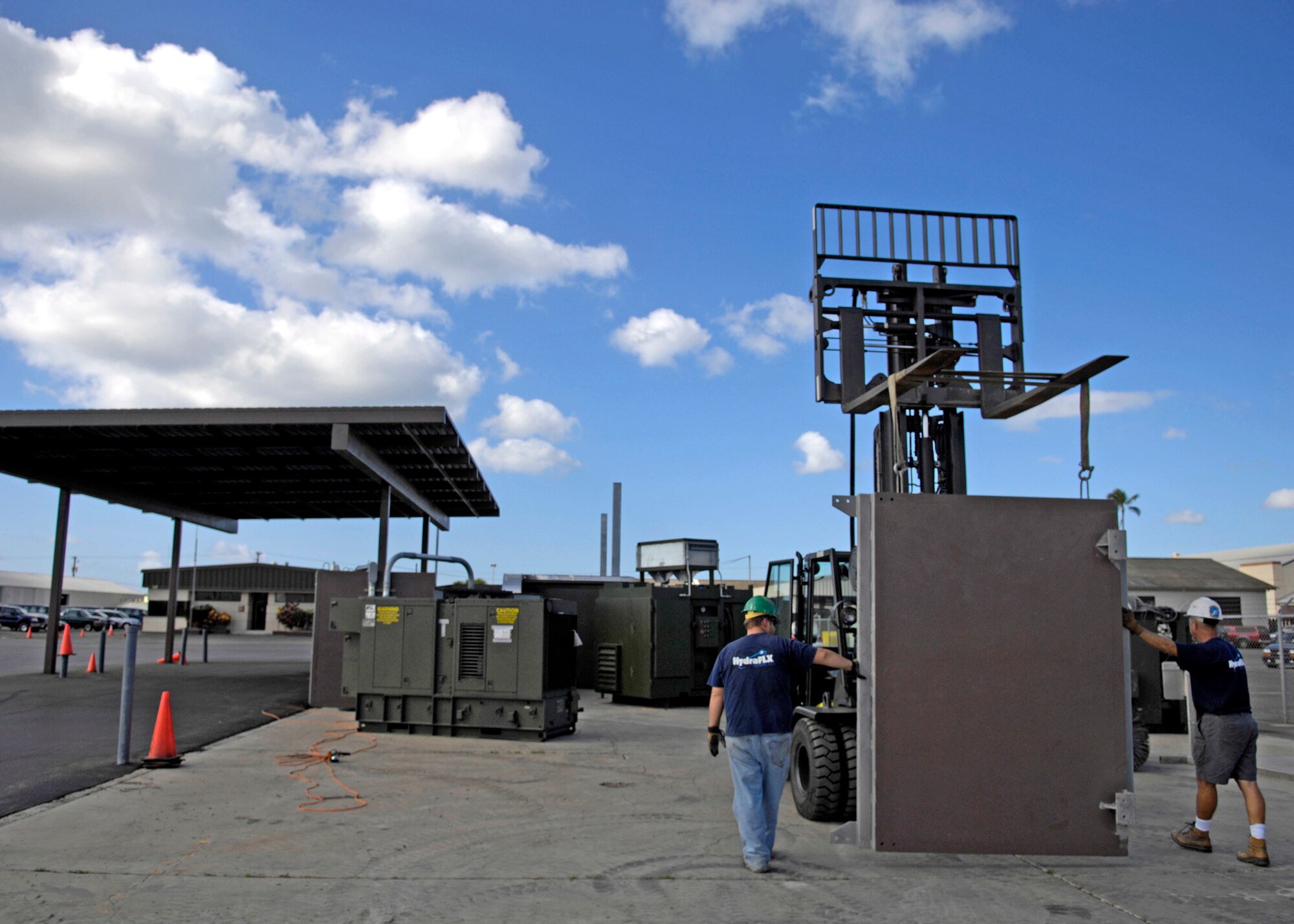 Members of HydraFLX Systems LLC move a containment wall during the building phase for the HydraFLX System at Hickam Air Force Base, Hawaii Oct. 27, 2006. The HydraFLX System is being tested by the Air Force as an alternate energy source. It will generate ultra-pure H2 (hydrogen) from water in a flexible pressure management process for fueling buses, tow-tractors, vans, sedans and ground support equipment. The system can also be deployed anywhere and operate in hostile theaters without infrastructure or pipelines. (U.S. Air Force photo/Tech. Sgt. Shane A. Cuomo)

