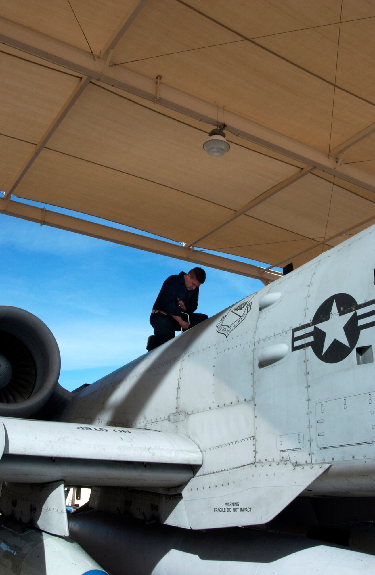 Staff Sergeant Astolfo Mercado closes a panel on an A-10 Thunderbolt II Oct. 28 on the flightline of Davis-Monthan Air Force Base, Ariz.  Sergeant Mercado is a crew chief from the 355th Aircraft Maintenance Squadron.  (U.S. Air Force photo/Airman 1st Class Alesia Goosic)
