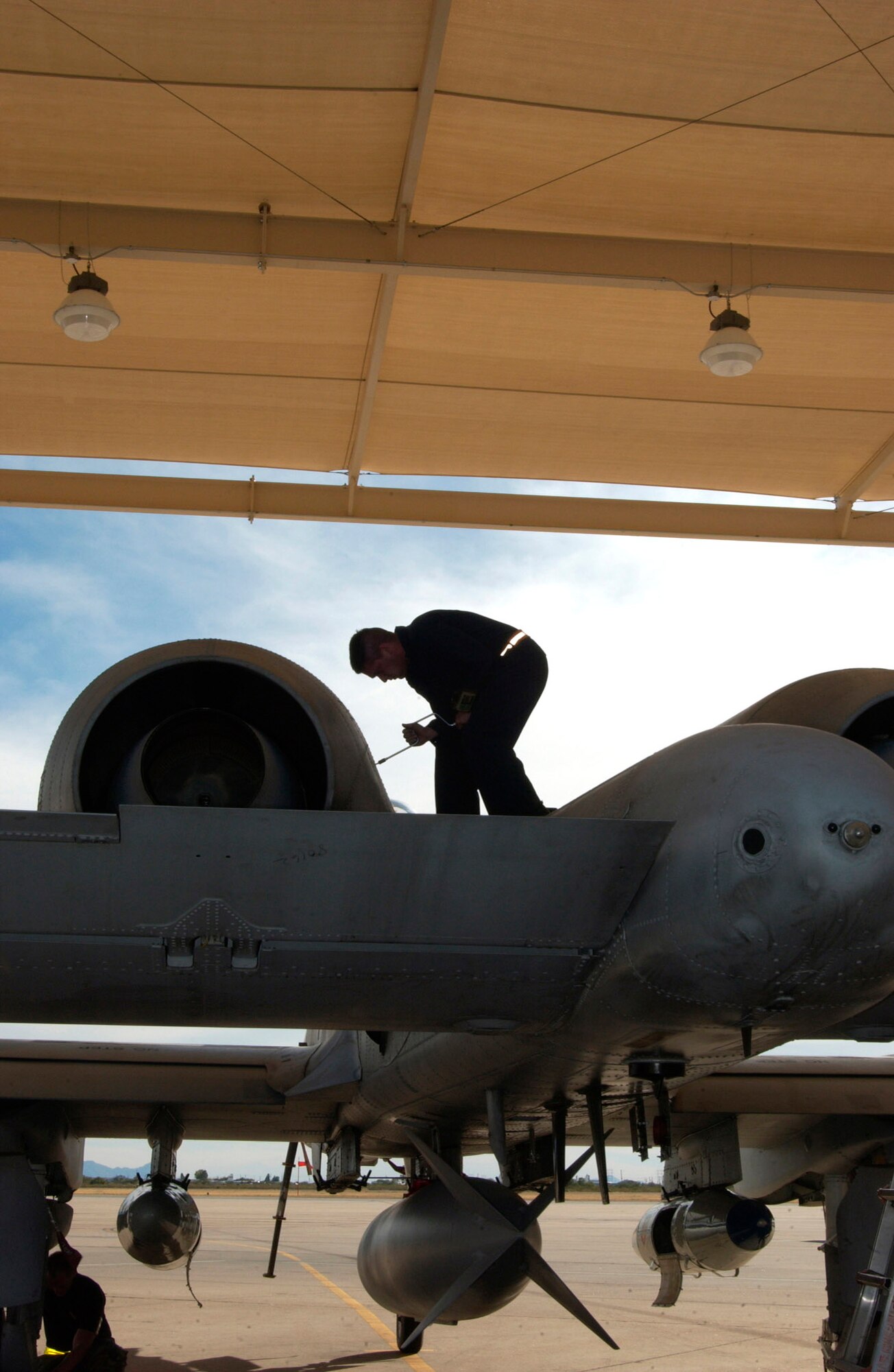 Staff Sergeant Astolfo Mercado closes a panel on an A-10 Thunderbolt II Oct. 28 on the flightline of Davis-Monthan Air Force Base, Ariz.  Sergeant Mercado is a crew chief from the 355th Aircraft Maintenance Squadron.  (U.S. Air Force photo/Airman 1st Class Alesia Goosic)
