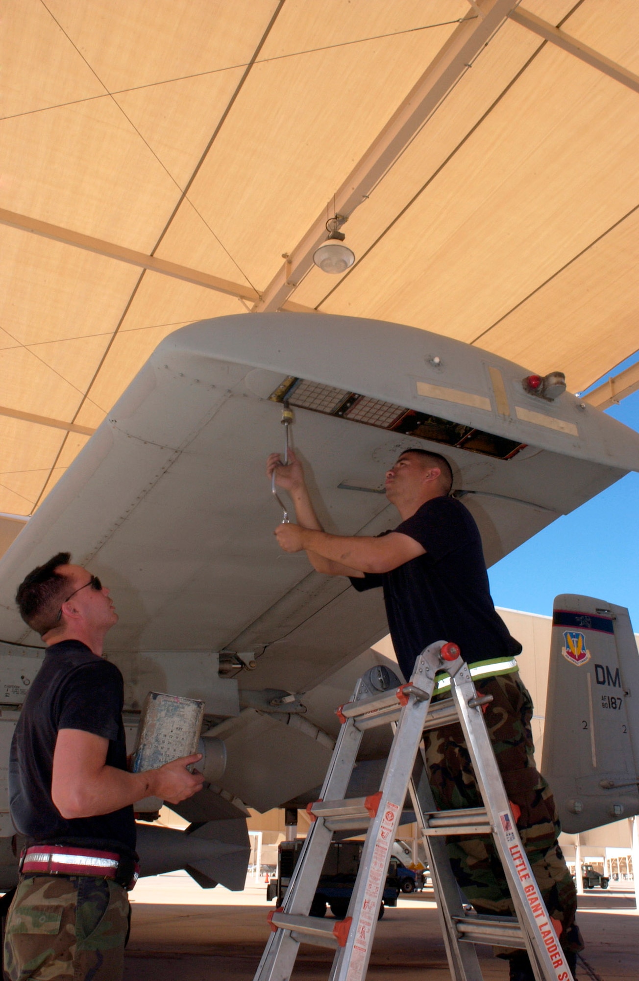 Senior Airmen Randy Loera (left) and Jesse Vida install chaff and flare dispensers on an A-10 Thunderbolt II Oct. 28 on the flightline of Davis-Monthan Air Force Base, Ariz. The Airmen are weapons loaders from the 355th Maintenance Operations Squadron.  (U.S. Air Force photo/Airman 1st Class Alesia Goosic)