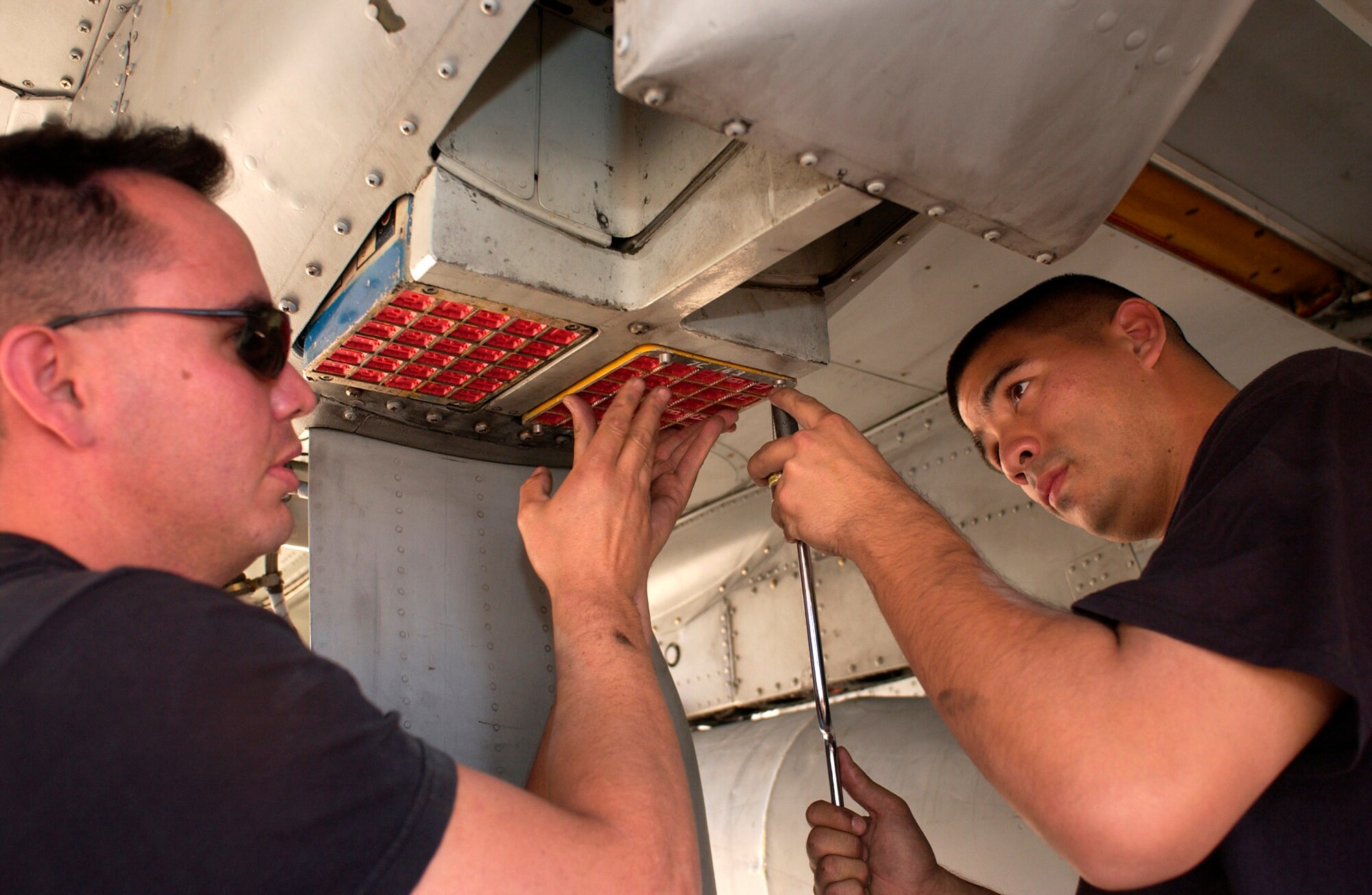Senior Airmen Randy Loera (left) and Jesse Vida install chaff and flare dispensers on an A-10 Thunderbolt II Oct. 28 on the flightline of Davis-Monthan Air Force Base, Ariz. The Airmen are weapons loaders from the 355th Maintenance Operations Squadron.  (U.S. Air Force photo/Airman 1st Class Alesia Goosic)