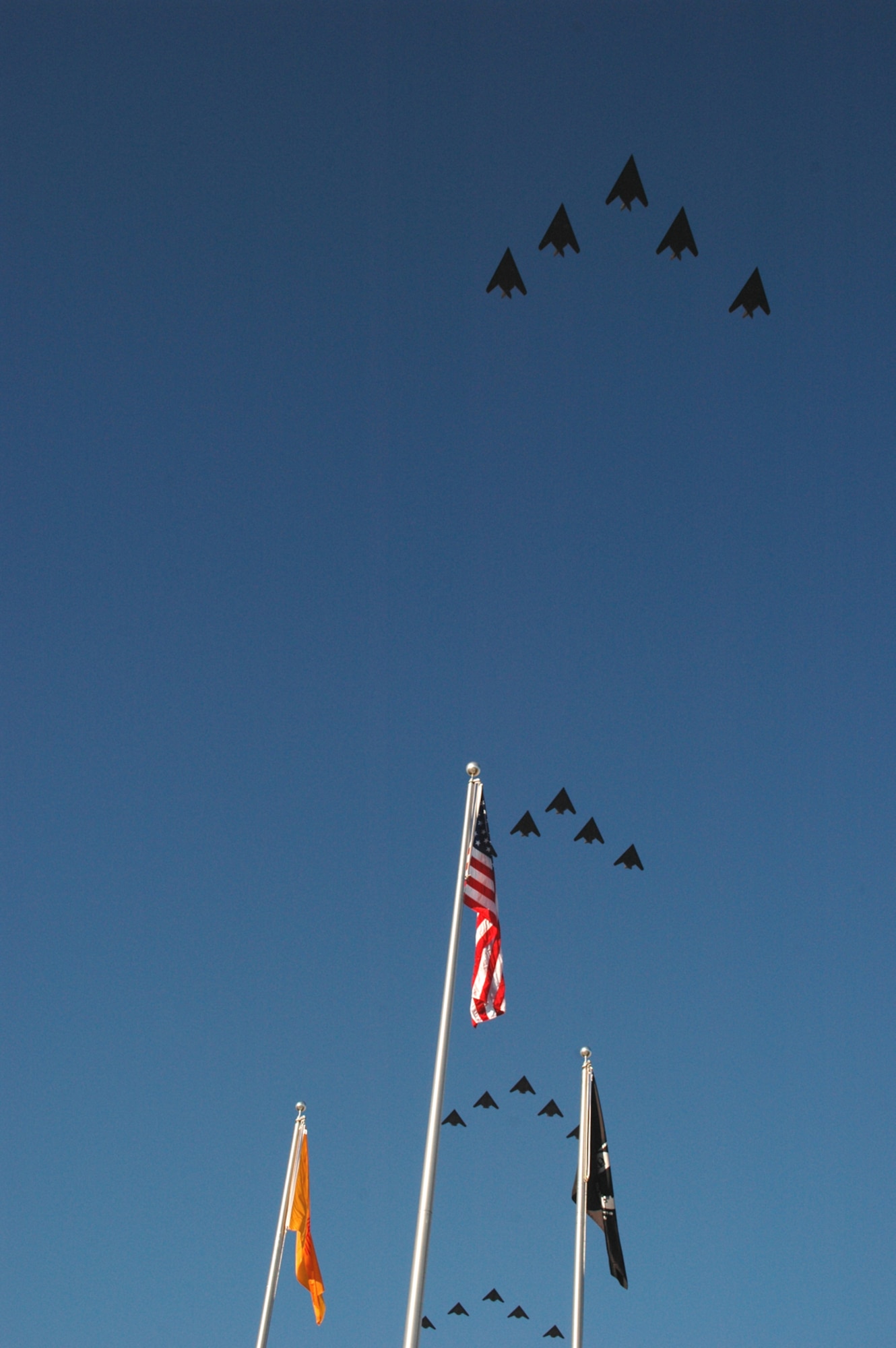 A large crowd watched as 25 F-117A aircraft pass over the flag pole at Heritage Park Oct. 27, 2006, for the Silver Stealth celebration at Holloman. The event was designed to celebrate the 25th year of the "hopeless diamond" and the 250,000 flying hour.