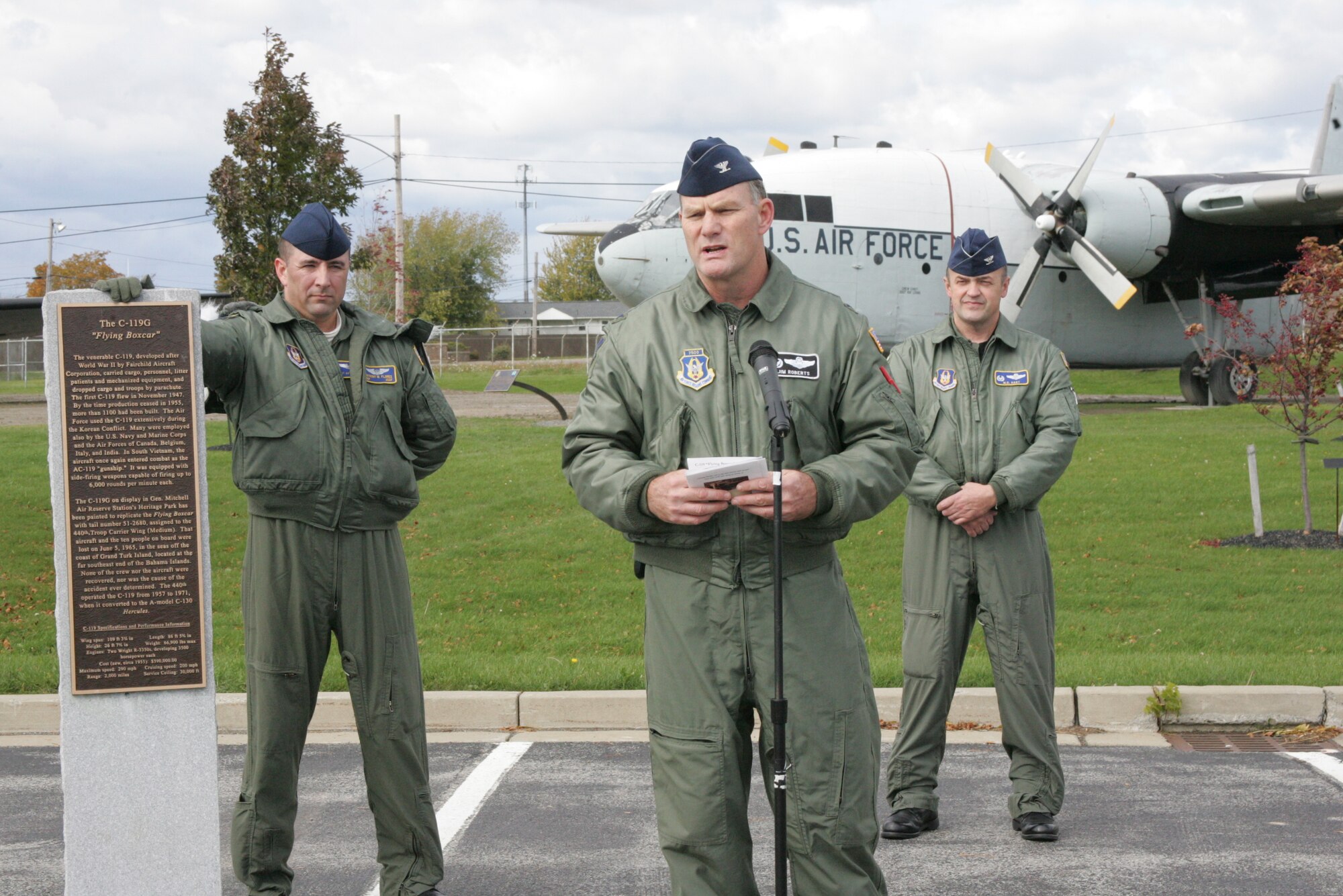NIAGARA FALLS AIR RESERVE STATION, NY- 914th AW Commander Col. James Roberts (center) speaks to a crowd during  the C-119 dedication ceremony held here recently while 440th AW Commander Col. Merle Hart (right) and Senior Master Sergeant Flores of the 440th AW (left) look on.  The C-119 was acquired from the 440th AW stationed at General Mitchell Air Reserve Station, Wisconsin.  Due to the Base Realignment & Closure Commissions decision to close Gen. Mitchell ARS all assets are being distributed and utilized throughout the Air Force.  The C-119 was dismantled at Gen Mitchell ARS, transported by tractor trailer to Niagara Falls ARS where it was reassembled and dedicated as a reminder to the 914th AW historical linage.  Photo by: Senior Master Sergeant (Ret.) Mike Harvey (Released)