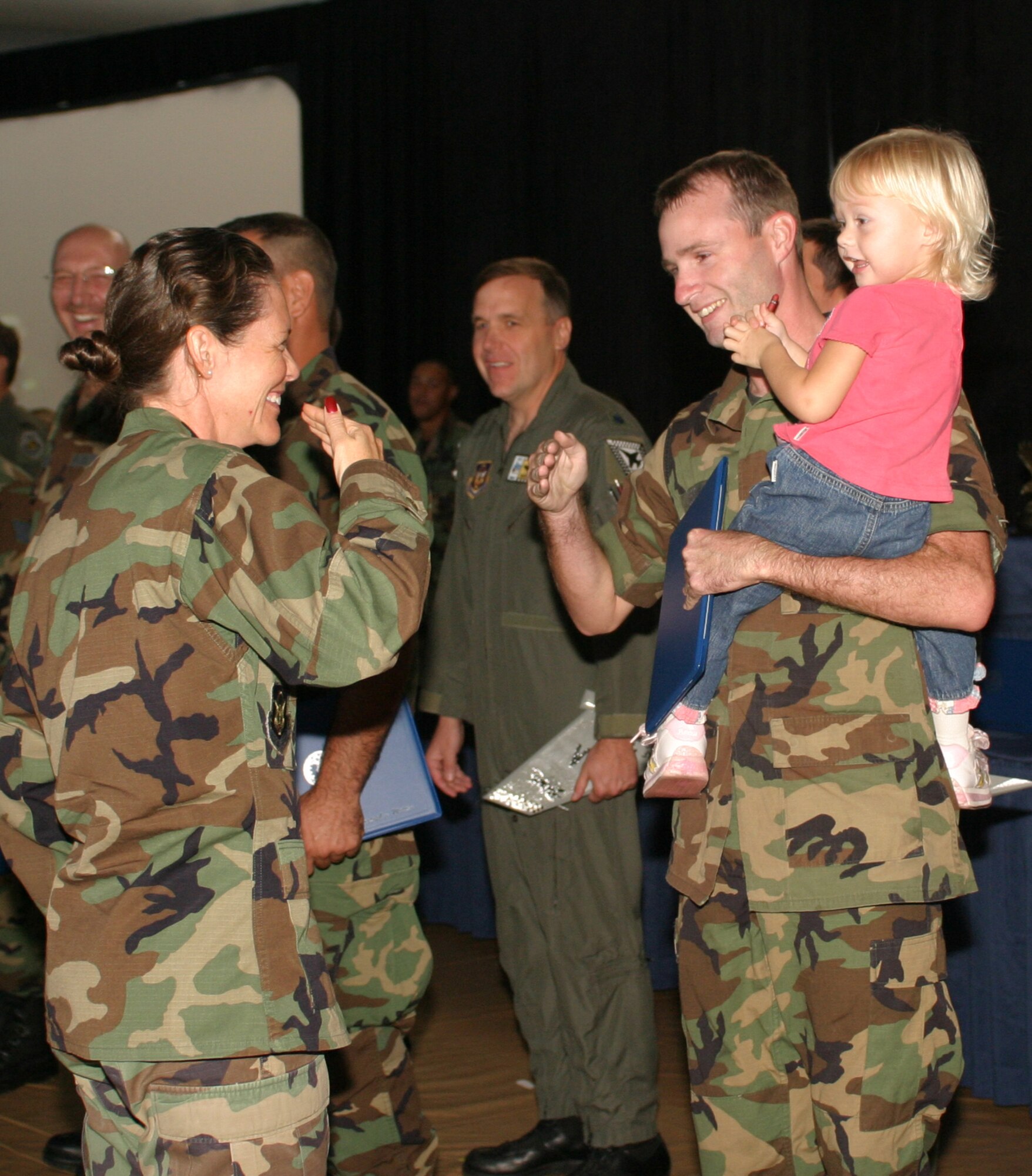 Tech. Sgt. Adam "Koz" Kosowsky, 482nd AMXS, was named dedicated crew chief for aircraft A-405 during the 482nd Maintenance Group's first annual awards ceremony on Oct. 15.  While accepting the miniature tail flash from his commander, Lt. Col. June Groff, Sgt. Kosowsky was greeted by his daughter Alexa who was obviously proud of her dad (Air Force photo by Tech. Sgt. Paul Dean).