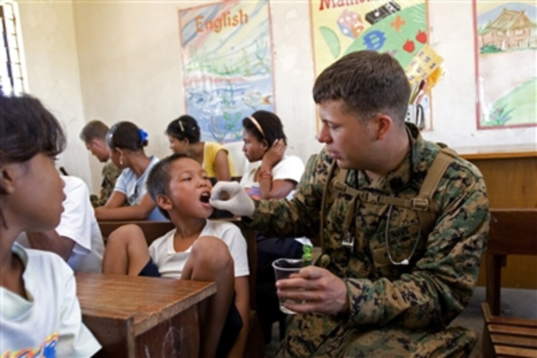 U.S. Navy Hospital Corpsman Apprentice Christopher Kline provides medication to a student at the Margulo Elementary School during a community relations project in the Barangay of Margulo, Municipality of Capas, Tarlac, Philippines, Oct. 21, 2006.