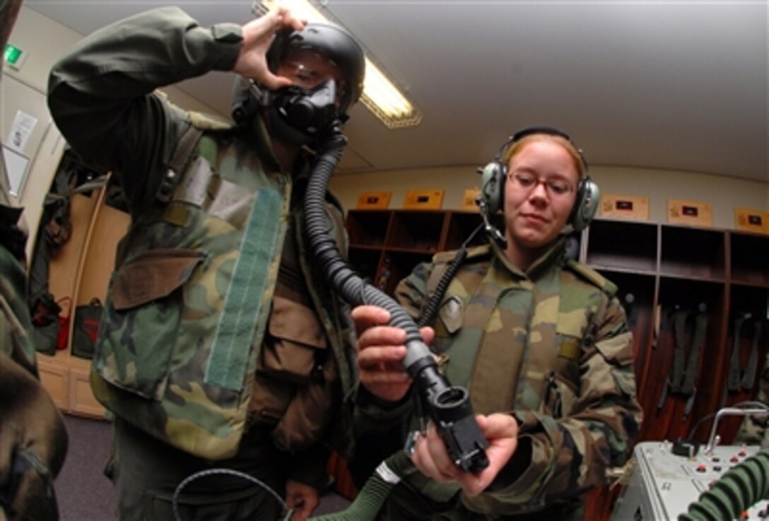 Air Force Airman 1st Class Victoria Watkins (right) checks the helmet of 1st Lt. Jason Roth prior to his flight during a combat capability exercise at Kadena Air Base, Japan, on Oct. 19, 2006.  