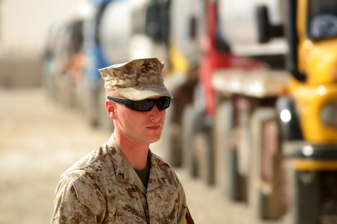 Pfc. Karl A. Dohrmann watches a truck while his fellow Marines and third-country nationals search through its compartments at Al Asad, Iraq, Oct. 31. Dohrmann is a patrolman with the Provost Marshal's Office, Alpha Battery, 3rd Low Altitude Air Defense Battalion, Marine Wing Support Group 37 (Reinforced), 3rd Marine Aircraft Wing (Forward). He is a native of Port Arthur, Texas.