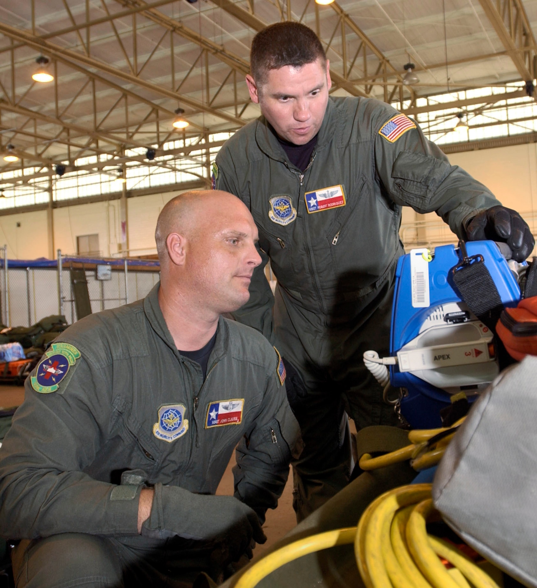 Master Sgts. John Clauss (left) and Rob Rodriguez perform an operational check-up on a defibrillator Sept. 5, 2005. The two flying medics helped aeromedical evacuation teams organize and load their equipment for flights to New Orleans to help evacuate victims of Hurricane Katrina. They are with the 433rd Airlift Wing at Lackland Air Force Base, Texas. (U.S. Air Force photo/Master Sgt. Jason Tudor)