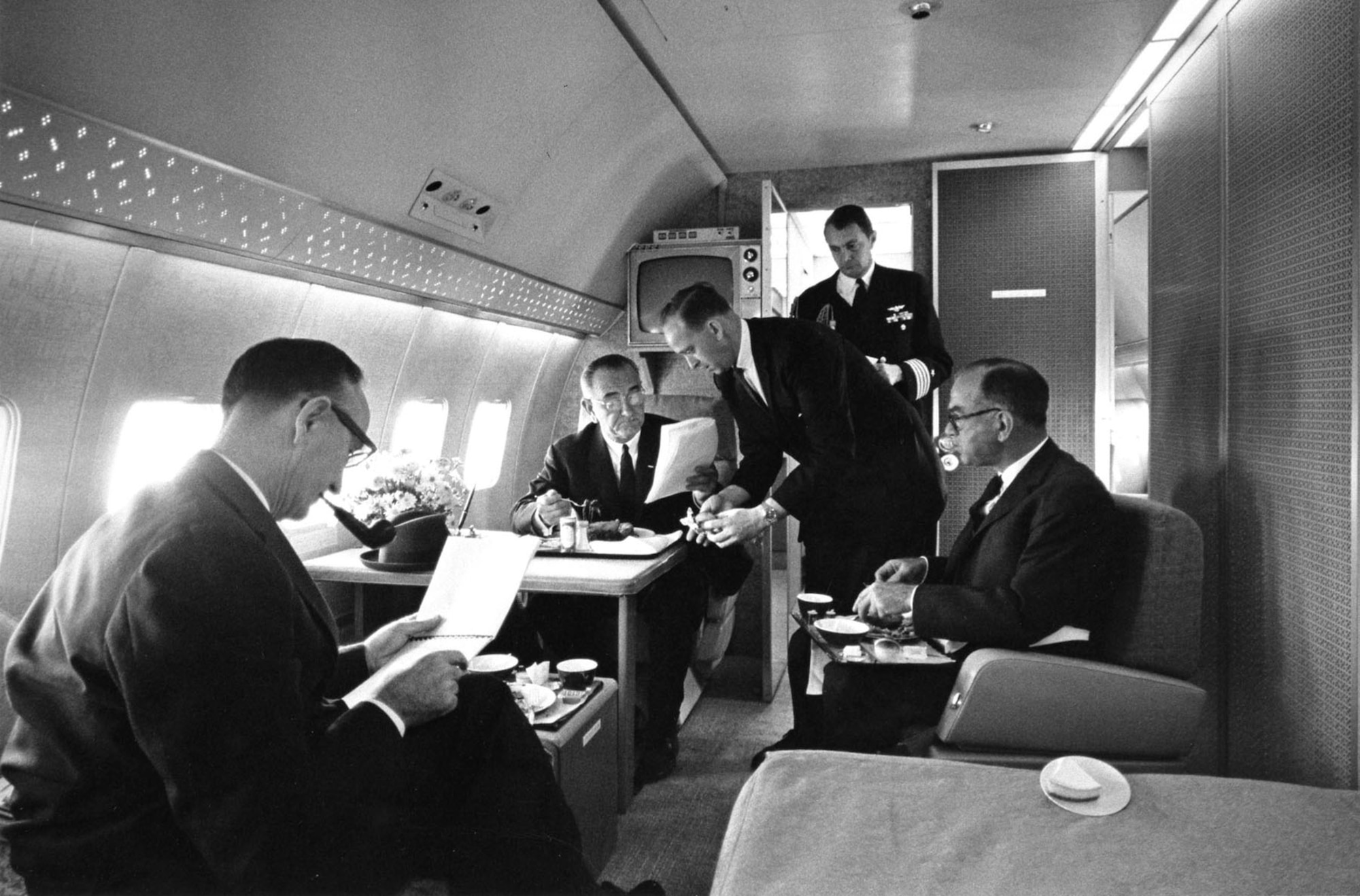 President Lyndon B. Johnson in the presidential bedroom aboard Air Force One (SAM 26000). From left to right are Sen. Mike Mansfield; President Johnson; Chief Master Sgt. Paul Glynn, serving president; U.S. Navy Aide Capt. Beach; and Sen. Fulbright. (U.S. Air Force photo)