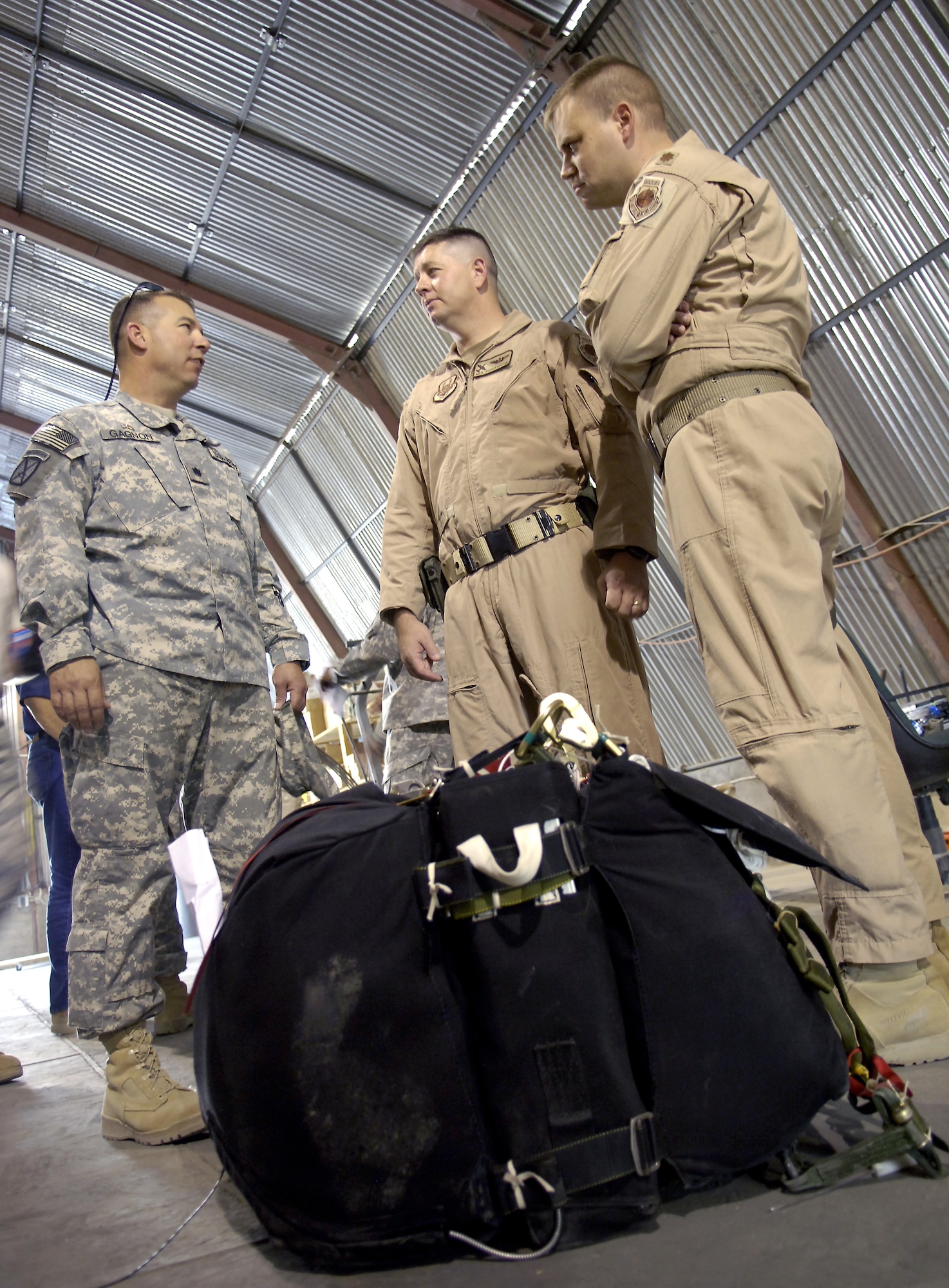 (From left) Army Lt. Col. Robert Gagnon, Maj. Neil Richardson and Maj. Daniel DeVoe review procedures for testing the new Joint Precision Air Drop System in Afghanistan. The system is designed to deliver airdrop loads to troops on the ground with more precision than the normal airdrop system. Colonel Gagnon is the deputy commander of the 10th Sustainment Brigade. Major DeVoe is the command tactician at the Air Mobility Warfare Center. Major Richardson is the chief of combat programs and policy branch at Air Mobility Command. (U.S. Air Force photo/Senior Airman Brian Ferguson) 