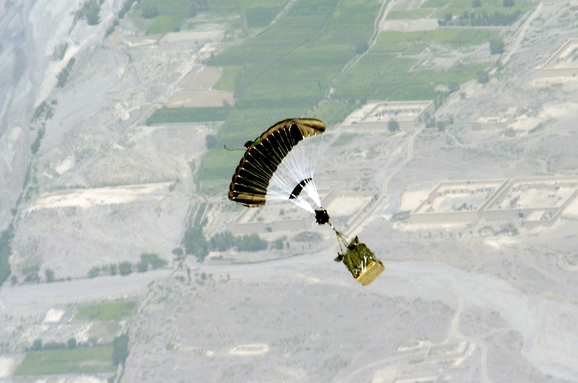 A new Global Positioning System-guided Joint Precision Air Drop System bundle, known as Screamer 2K, floats to the ground after being dropped from the back of a C-130 Hercules over Afghanistan Aug. 31. The drop was made from 17,500 feet above sea level, and was the first joint Air Force-Army operational drop of JPADS in the U.S. Central Command area of responsibility. Four bundles were dropped from the Alaska Air National Guard C-130. All four bundles arrived at the drop zone, resupplying Army troops on the ground with ammunition and water. (U.S. Air Force photo/Senior Airman Brian Ferguson) 