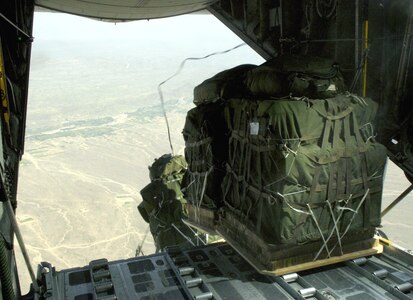 Joint Precision Air Drop System bundles fall out of the back of a C-130 Hercules Aug. 25. The drop was made from almost 10,000 feet above sea level and was calculated using up-to-the-minute wind data relayed from two small dropsondes deployed 20 minutes earlier. The dropsondes calculate wind speed and relay the information back to the aircraft, helping to calculate the correct drop point. (U.S. Air Force photo/Senior Airman Brian Ferguson) 