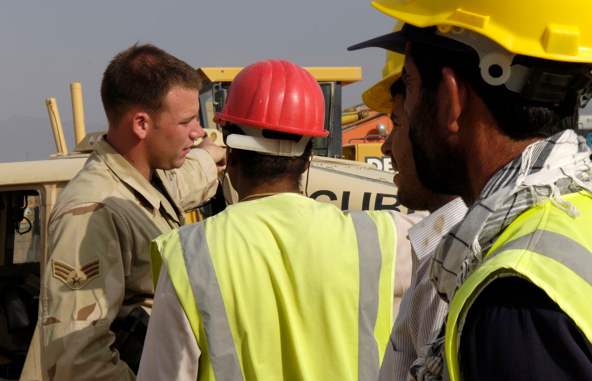 Senior Airman Robert Elliott talks with one of the Afghan workers extending the flight line ramp here at Bagram Air Base, Afghanistan, Aug 24, 2006.  Airman Elliott is a force protection escort here.  He is deployed from Pope Air Force Base, NC.  
(U.S. Air Force photo/Senior Airman Brian Ferguson)


