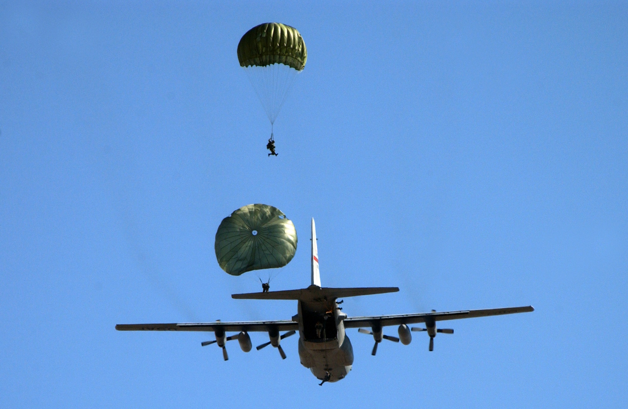 Pararescue personnel from the 414th Combat Training Squadron and parachutists from the 820th Red Horse Squadron, Nellis Air Force Base, Nev., jump out a C-130J Hercules Sept. 1, 2006, over the Nevada Test and Training Ranges in support of Red Flag Exercise 06-2. (U.S. Air Force photo/Master Sgt. Kevin J. Gruenwald) 
