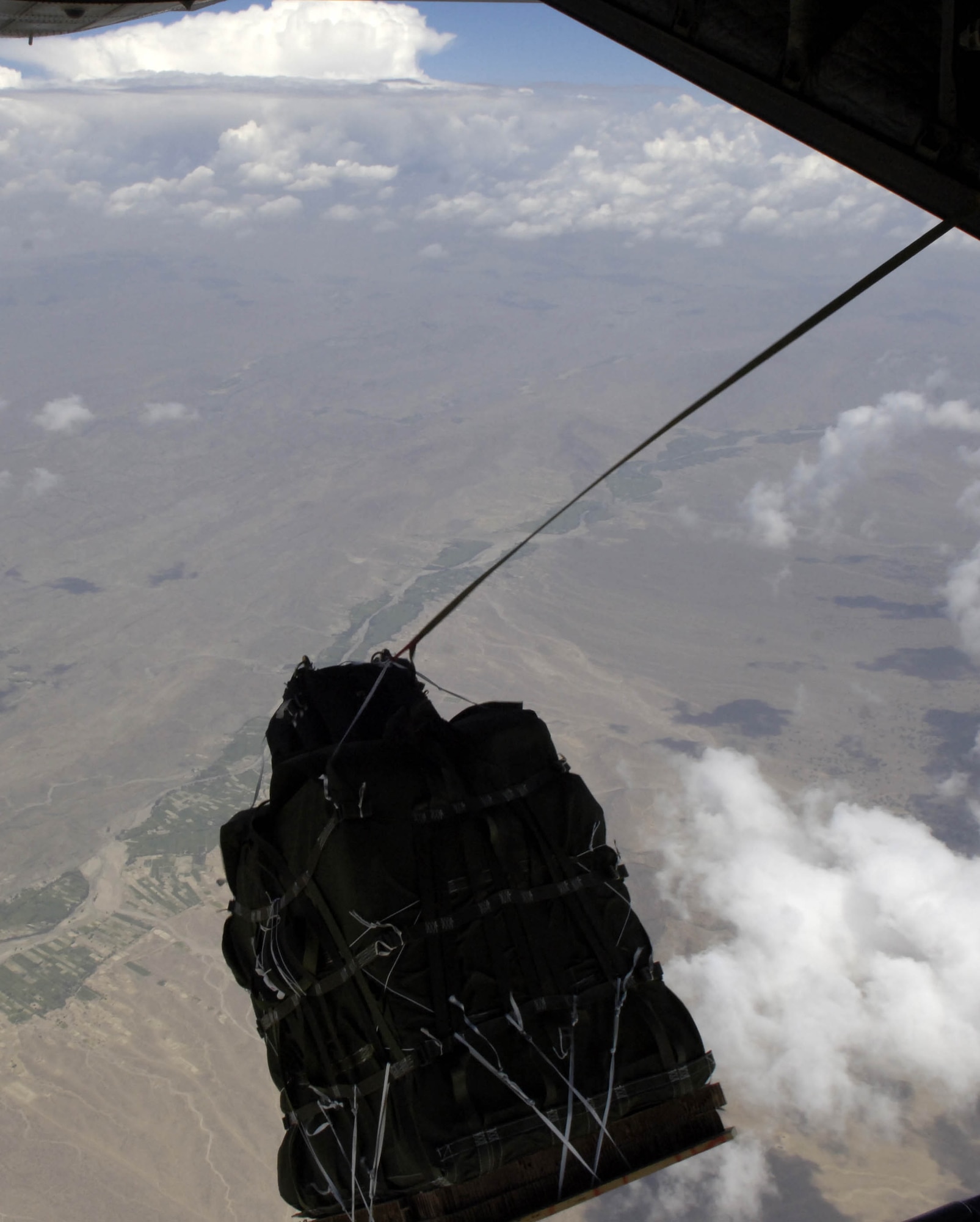 The new GPS guided Screamer 2K bundle, Joint Precision Air Drop System, fall out of the back of a C-130 Hercules over Afghanistan Aug. 26, 2006 over.  The drop was made from 17,500 feet above mean sea level, and was the first joint Air Force Army operational drop of JPADS in the Central Command Area of Responsibility.  Four bundles were dropped from the Alaska Air National Guard C-130.  The system is designed to provide precision airdrops from high altitudes, elimination the treat of small arms fire.  All four bundles arrived at the drop zone, less than 25 meters from the desired target.    
(U.S. Air Force photo/Senior Airman Brian Ferguson)

