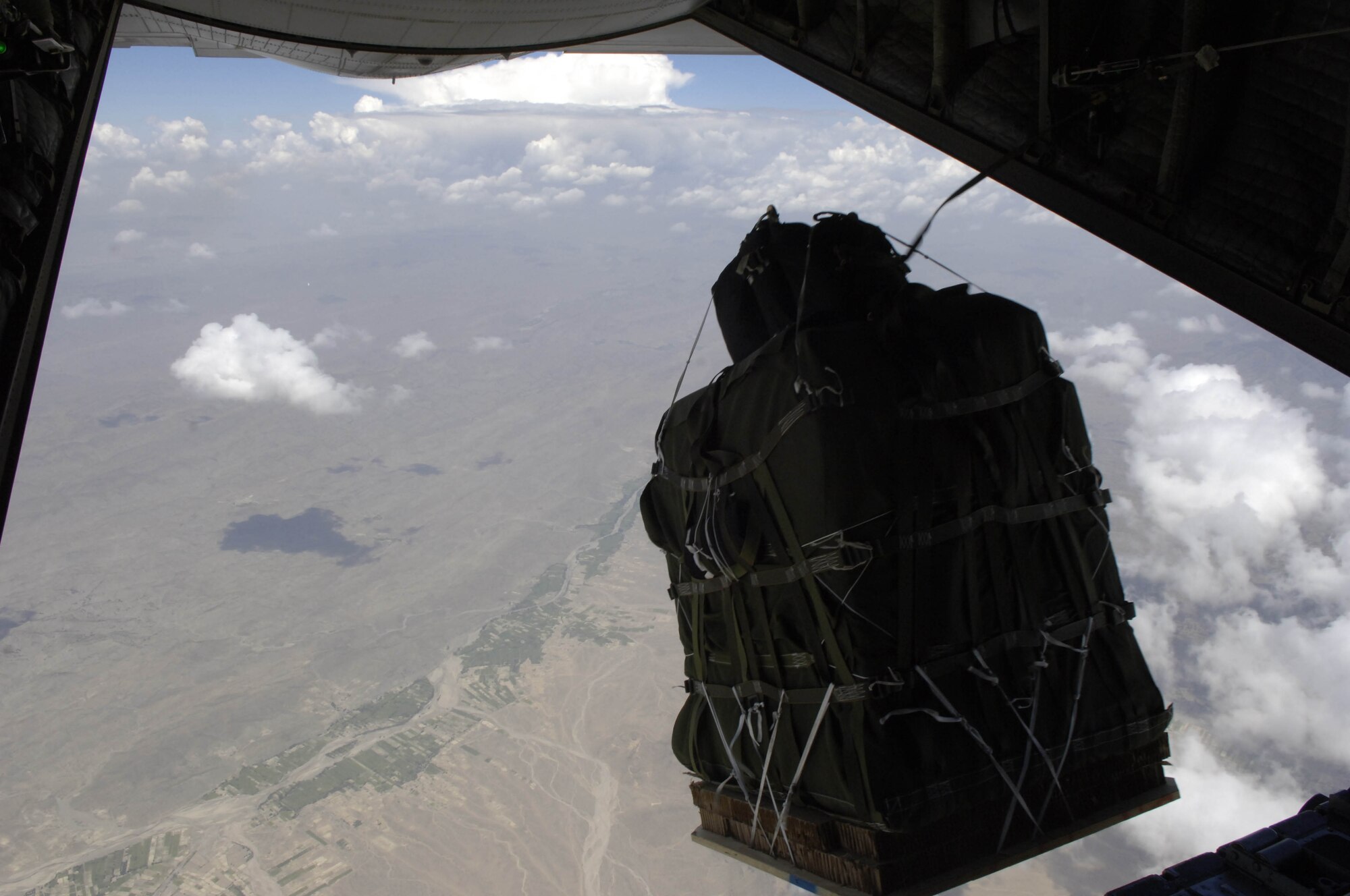 The new GPS guided Screamer 2K bundle, Joint Precision Air Drop System, fall out of the back of a C-130 Hercules over Afghanistan Aug. 26, 2006.  The drop was made from 17,500 feet above mean sea level, and was the first joint Air Force Army operational drop of JPADS in the Central Command Area of Responsibility.  Four bundles were dropped from the Alaska Air National Guard C-130.  The system is designed to provide precision airdrops from high altitudes, elimination the treat of small arms fire.  All four bundles arrived at the drop zone, less than 25 meters from the desired target.    
(U.S. Air Force photo/Senior Airman Brian Ferguson)
