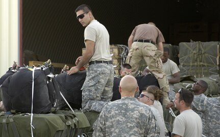 Parachute riggers with the 647th Quartermaster Detachment rig the new Joint Precision Air Drop System in Bagram Afghanistan Aug. 25, 2006. The system, going through operational testing here, is designed to deliver airdrop loads to troops on the ground with more precision than the normal airdrop system.  
(U.S. Air Force photo/Senior Airman Brian Ferguson)
