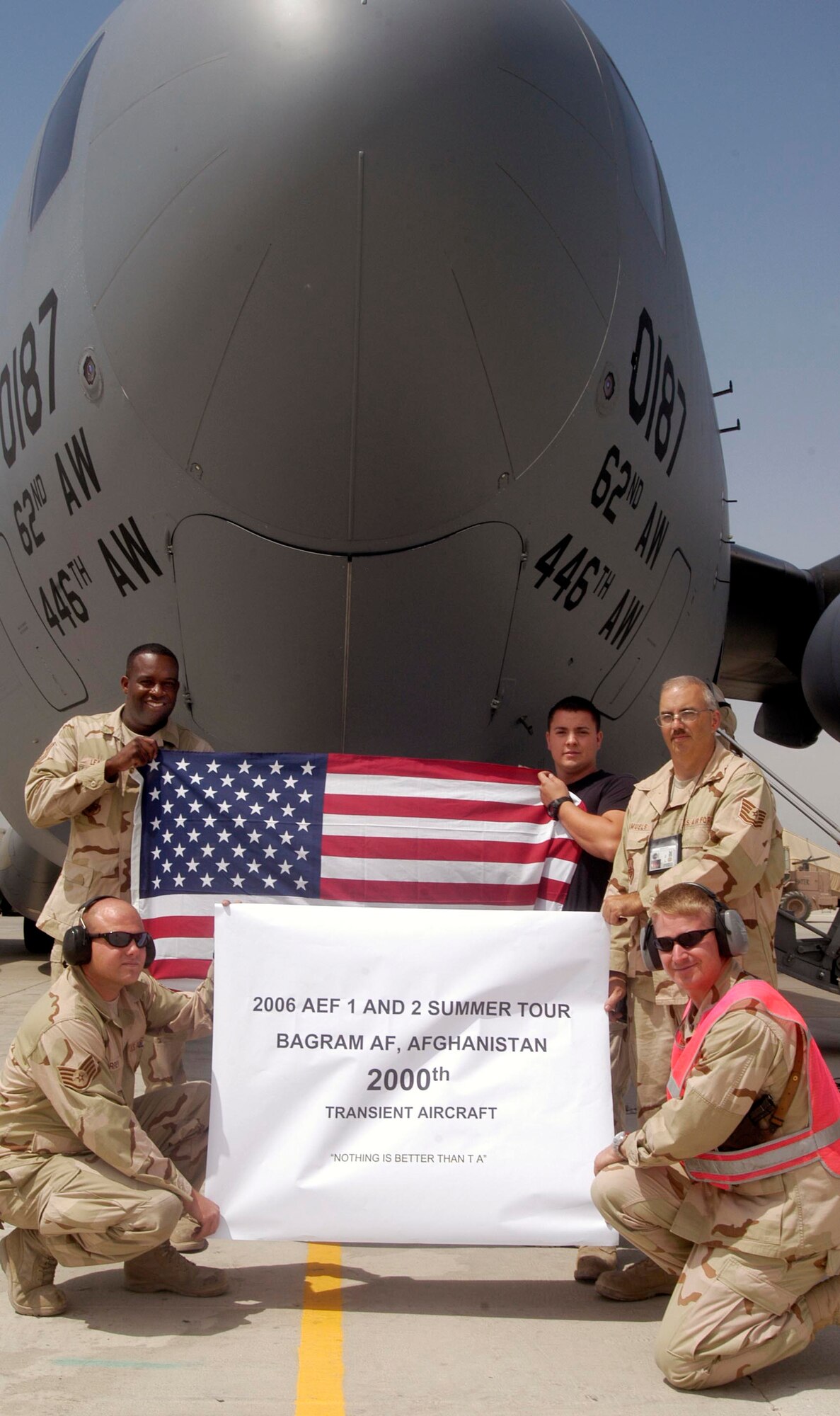 Members of the transient alert and air terminal operations center pose underneath a C-17, which was the 2,000th transient aircraft to land at Bagram Airfield, Afghanistan, for the Air Expeditionary Force one and two rotation, which began May 7.  Standing, from left, Tech. Sgt. Michael Leach, 455th Expeditionary Maintenance Squadron; Senior Airman Logan B. Deal Figueroa, 455th Expeditionary Logistics Readiness Squadron; and Tech. Sgt. Robert Samuels, 455th EMXS.  Kneeling, from left, Staff Sgt. Gordon Torrey, 455th EMXS; and Maj. Timothy Coger, 455th EMXS commander. The transient alert and ATOC team at Bagram have averaged almost 17 aircraft per day since May 7.  A transient aircraft is one that arrives at Bagram to unload, or load, cargo and passengers to support Operation Enduring Freedom, then takes off again and is not assigned here. (US Air Force photo/Maj. David Kurle) 