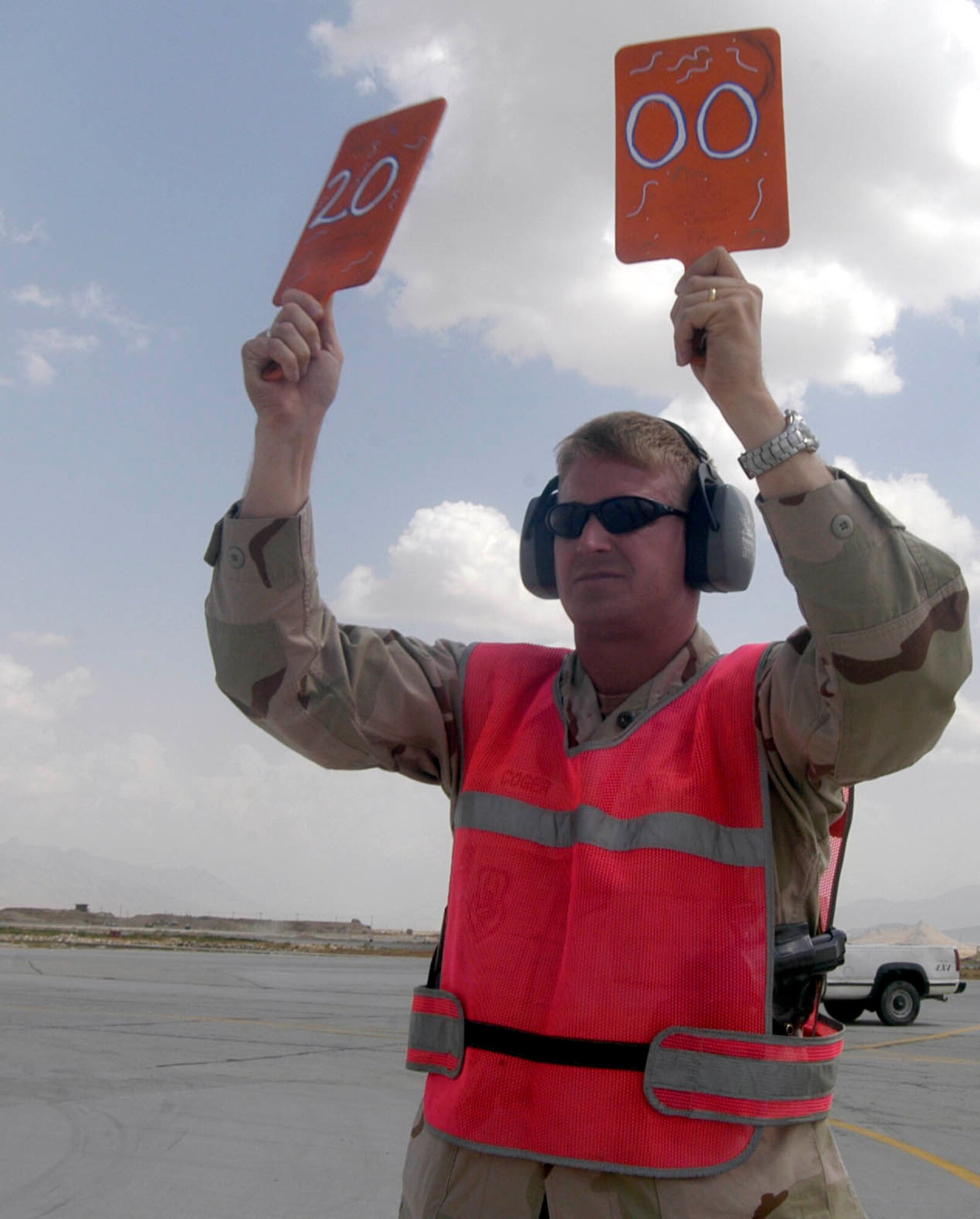 Maj. Timothy Coger uses paddles to direct a C-17 into its parking spot Sept. 2, at Bagram Airfield, Afghanistan.  The major is the commander of the 455th Expeditionary Maintenance Squadron at Bagram.  The C-17, from the 62nd Airlift Wing, McChord Air Force Base, Wash., was the 2,000th transient aircraft to land at Bagram for Air Expeditionary Force one and two, which began May 7, for the transient alert team here.  Two-thousand planes equates to an average of almost 17 aircraft transiting Bagram per day.  Transient aircraft are those that arrive at Bagram to unload, or load, cargo and passengers to support Operation Enduring Freedom, then take off again and are not assigned here. Major Coger is deployed to Bagram from Spangdahlem Air Base, Germany.  (US Air Force photo/Maj. David Kurle)                                