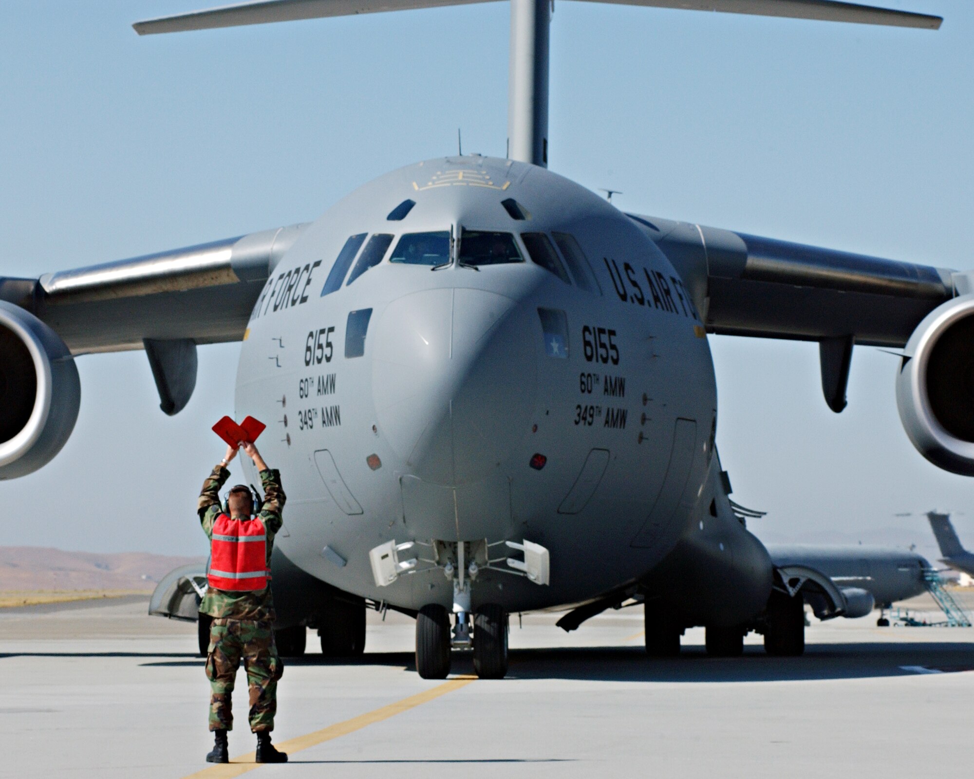 C-17 piloted by Brigadier Gen. Buddy Reed taxis in as crewchief Staff Sgt. Jeffrey Eckert directs the aircraft to its parking location at Travis AFB. The arriving C-17 is the second of thirteen that will be stationed at Travis. Photo by David W. Cushman GS-11