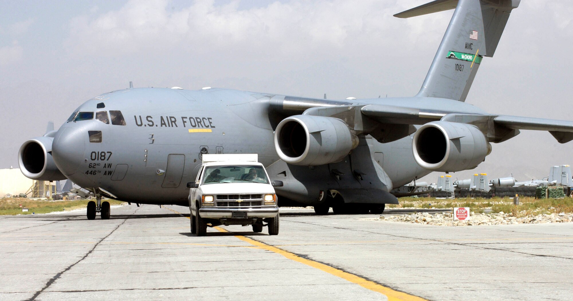 Tech. Sgt. Michael Leach and Staff Sgt. Gordon Torrey drive a "follow-me" truck to guide a C-17 Globemaster III to its parking spot at Bagram Air Base, Afghanistan, Sept. 2. The C-17, from the 62nd Airlift Wing at McChord Air Force Base, Wash., was the 2,000th transient aircraft to land at Bagram for Air Expeditionary Forces 1 and 2, which began May 7. That number equates to an average of 17 aircraft transiting Bagram daily. Sergeant Leach is deployed from Tinker Air Force Base, Okla., and Sergeant Torrey is from Pope AFB, N.C. (U.S. Air Force photo/Maj. David Kurle)