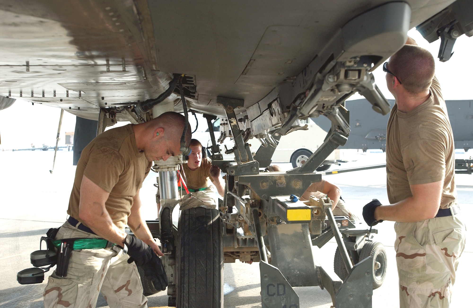 (From left) Staff Sgt. Warren Johnson, Senior Airman Paul Moore, Staff Sgt. Dave Kelley and Staff Sgt. Kiel Nichols install a fuel tank on an F-15E Strike Eagle at a forward-operating base in Southwest Asia Sept. 1. The Airmen are crew chiefs deployed from the 335th Aircraft Maintenance Unit at Seymour Johnson Air Force Base, N.C. (U.S. Air Force photo/Master Sgt. John DeGroot) 