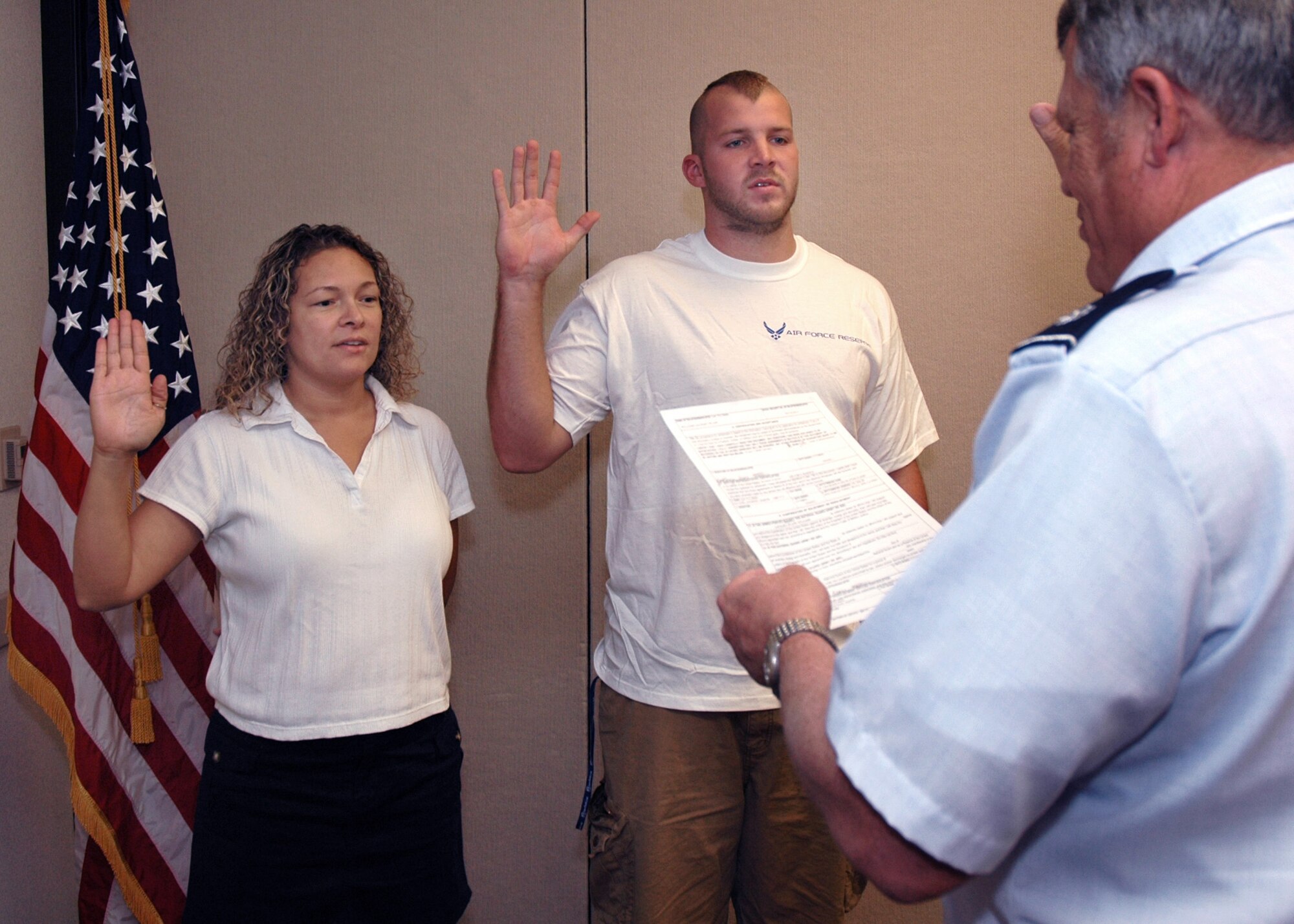 08-31-06 BEALE AIR FORCE BASE, Calif. -- Airmen 1st Class Casandra Redd and Zach Williams take the oath of enlistment, administered by Chaplain (Lt. Col.) Mike Murphy. The two Airmen joined on the last of the recruiting year, helping the Beale AFB detachment of Air Force Reserve Command recruiters meet their 2006 goal.   Airman Redd is coming into the 940th Air Refueling Wing from the U.S. Navy. Airman Williams is new to the military. He will serve with the 349th Air Mobility Wing, Travis AFB, Calif., after completion of his initial military training.  (U.S. Air Force photo/Maj. Robert Couse-Baker)