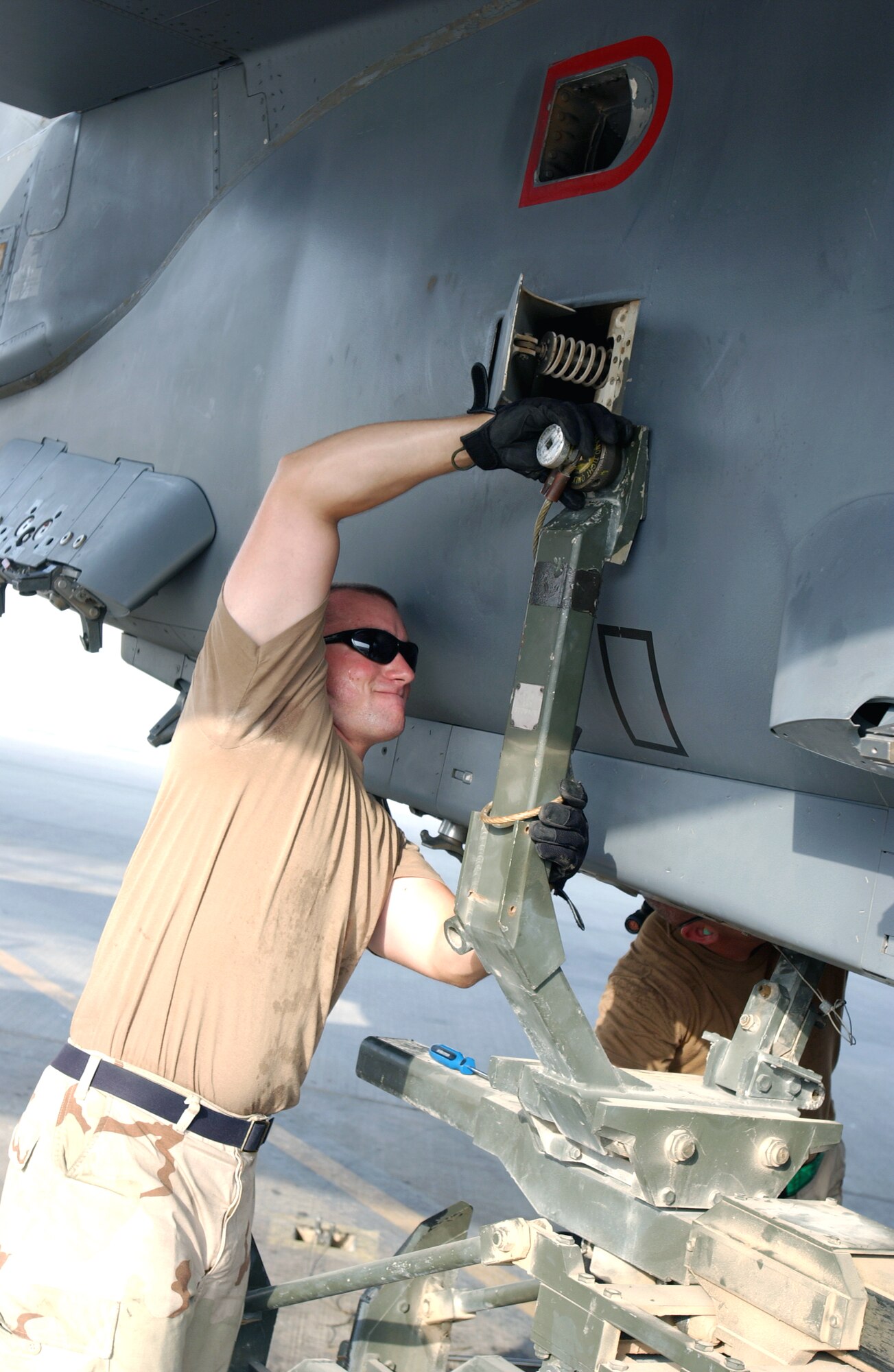 Staff Sgt. Kiel Nichols installs a fuel tank on an F-15E Strike Eagle at a forward-operating base in Southwest Asia Sept. 1. Sergeant Nichols is a crew chief deployed from the 335th Aircraft Maintenance Unit at Seymour Johnson Air Force Base, N.C. (U.S. Air Force photo/Master Sgt. John DeGroot) 